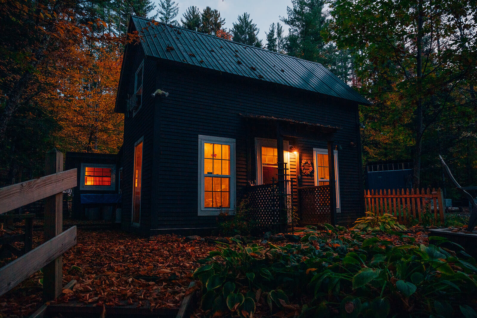  Cabin in the woods glowing during the early morning before a Vermont elopement in the Fall 