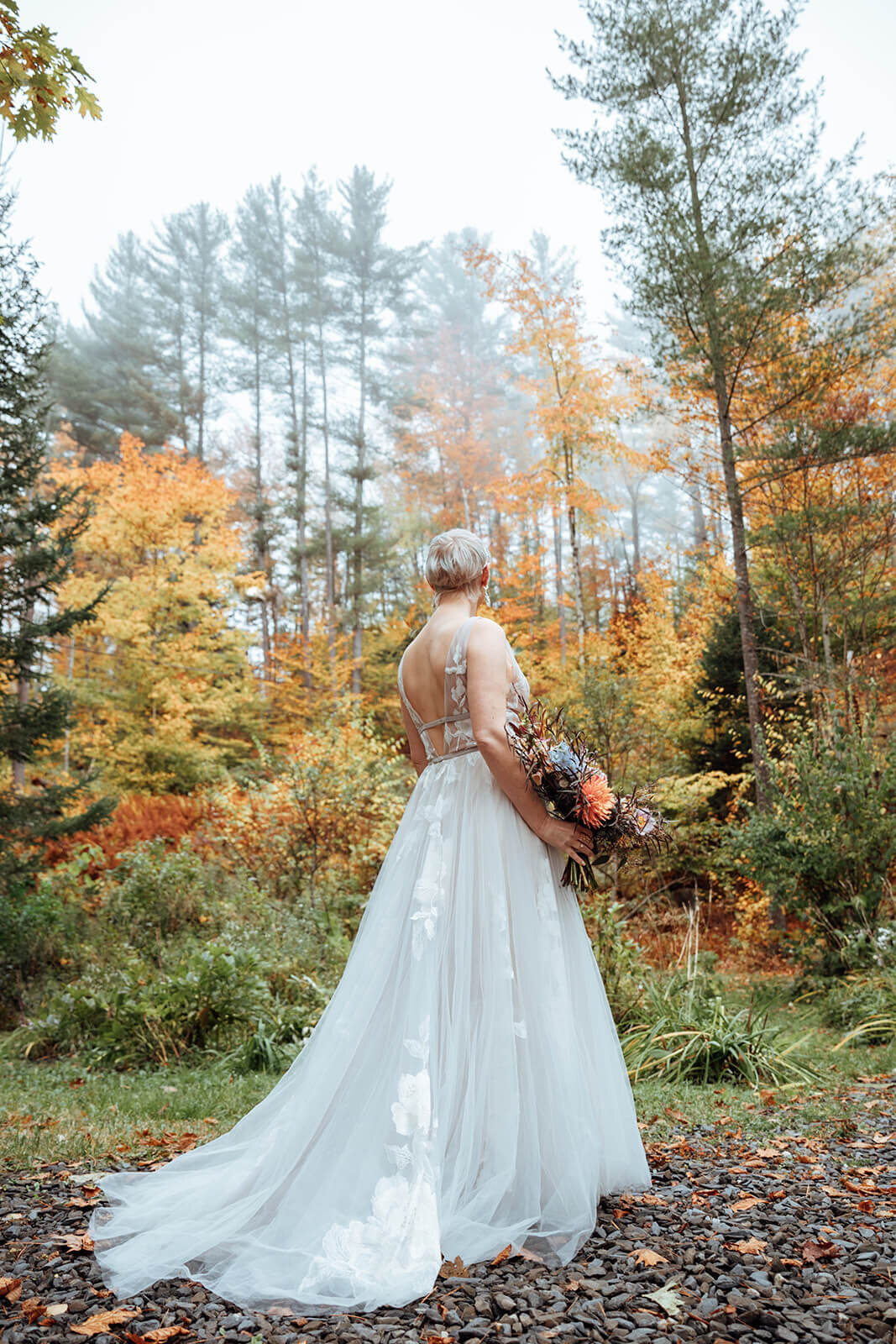  Bride checks out the autumn colors surrounds her cabin in the woods in Vermont 