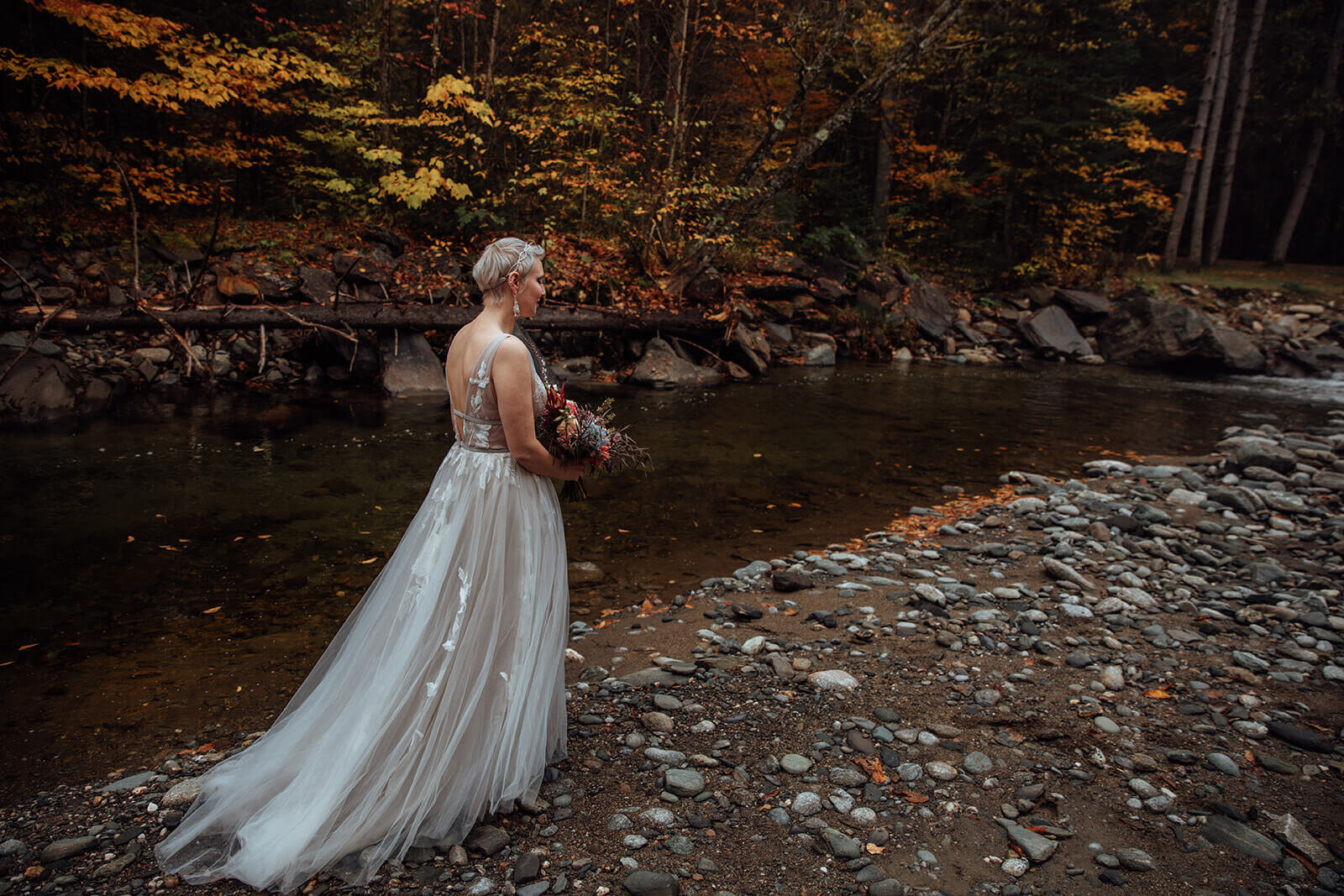  Bride checks out the autumn colors surrounding her cabin in the woods in Vermont 