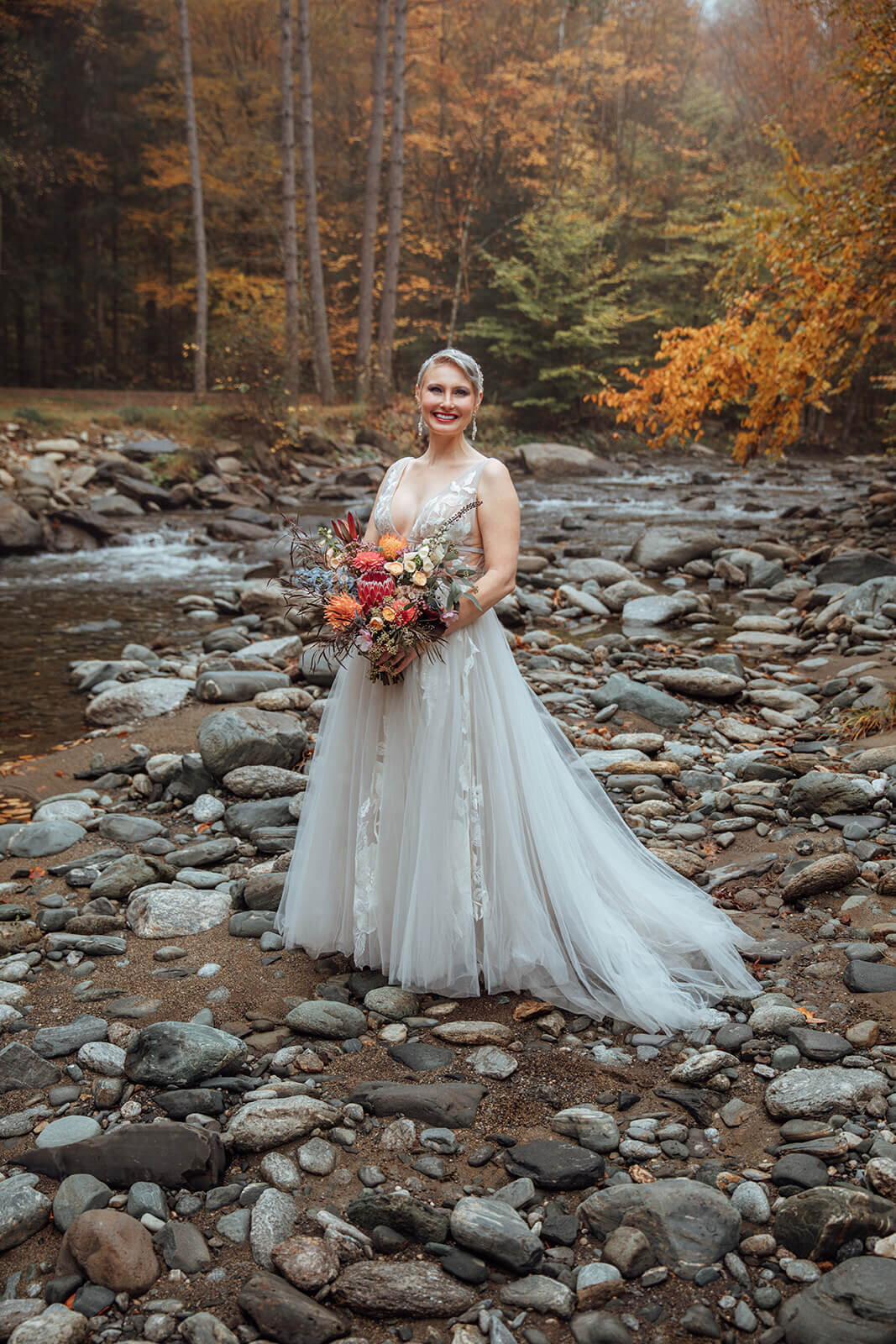  Bride checks out the autumn colors surrounding her cabin in the woods in Vermont 