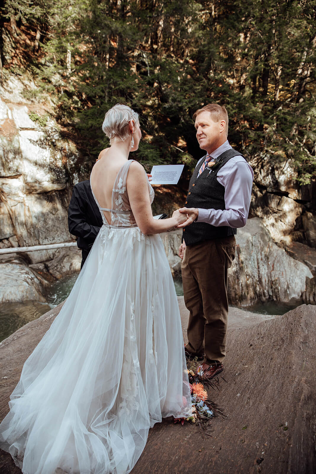  Bride reads her vows to the groom during elopement ceremony at Warren Falls in Vermont 