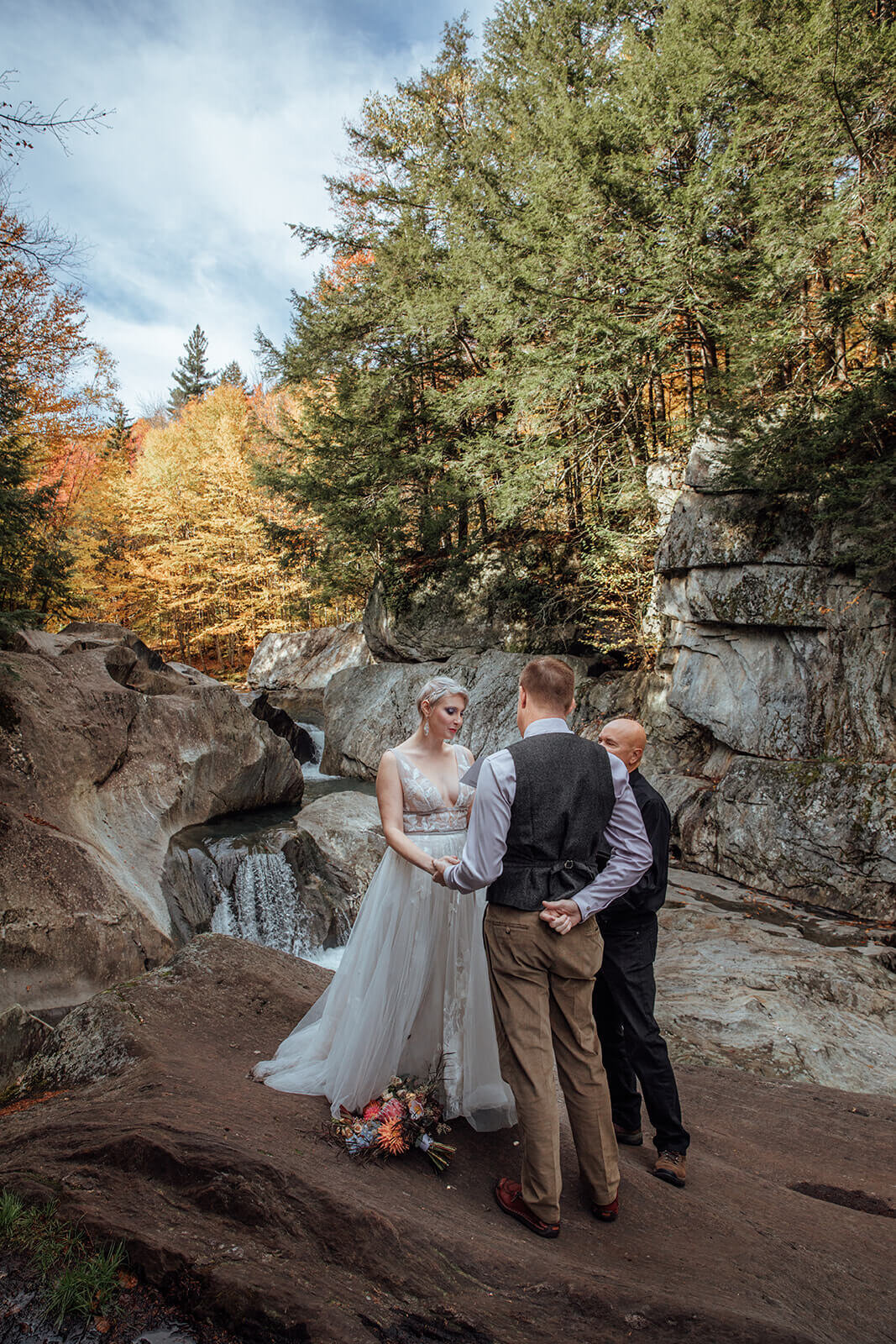  Bride reads her vows to the groom during elopement ceremony at Warren Falls in Vermont 