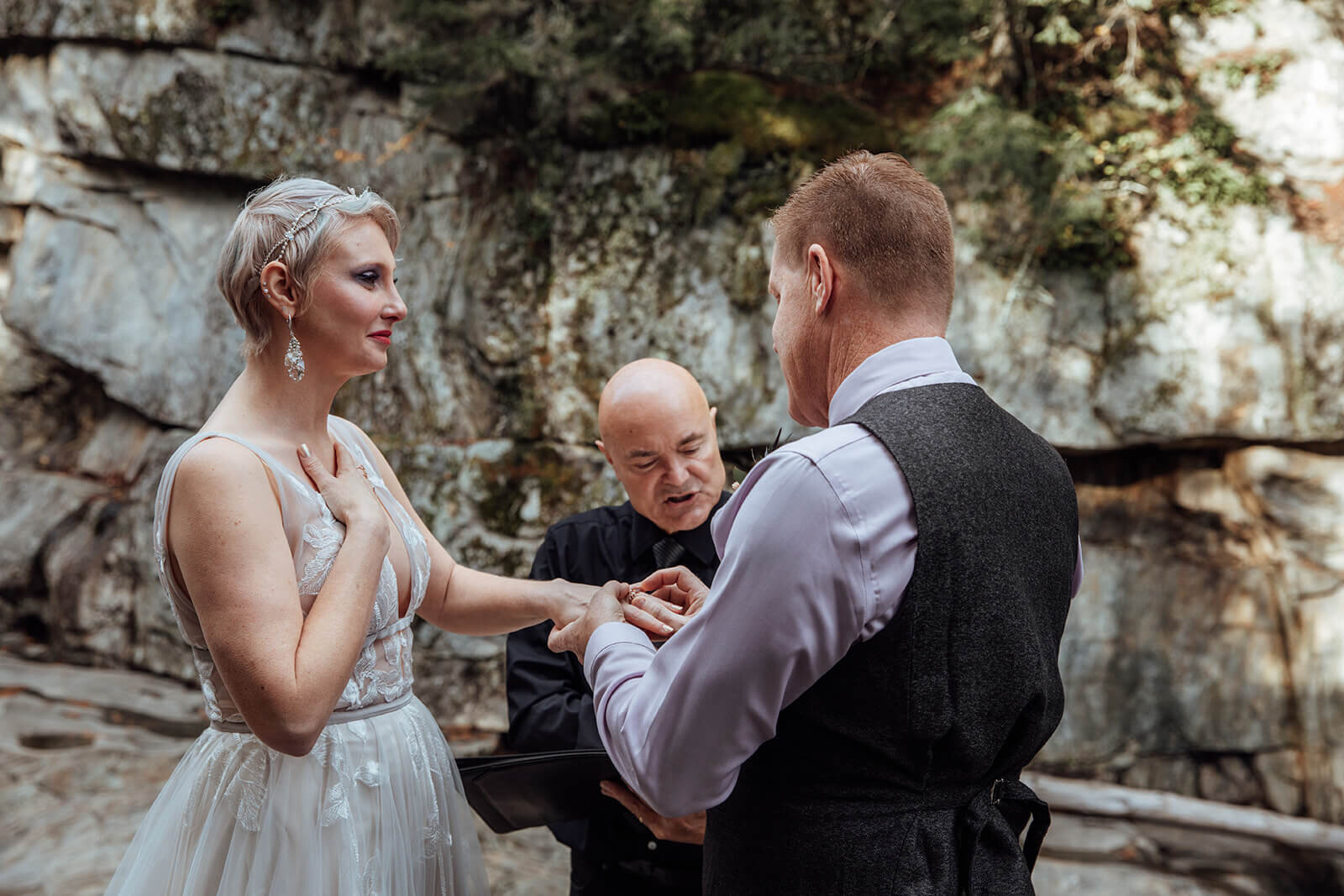  Couple exchanges rings during their elopement ceremony at Warren Falls in Vermont 