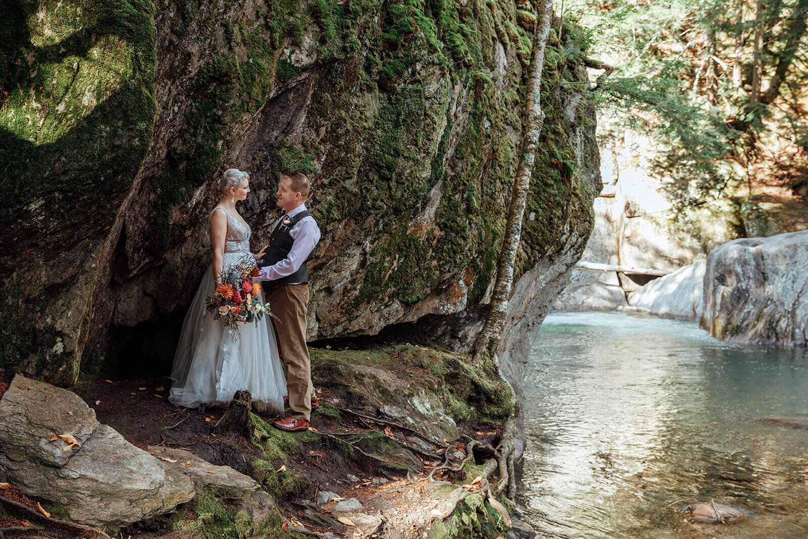  Bride and groom check out the Mad River after eloping at Warren Falls in Vermont 