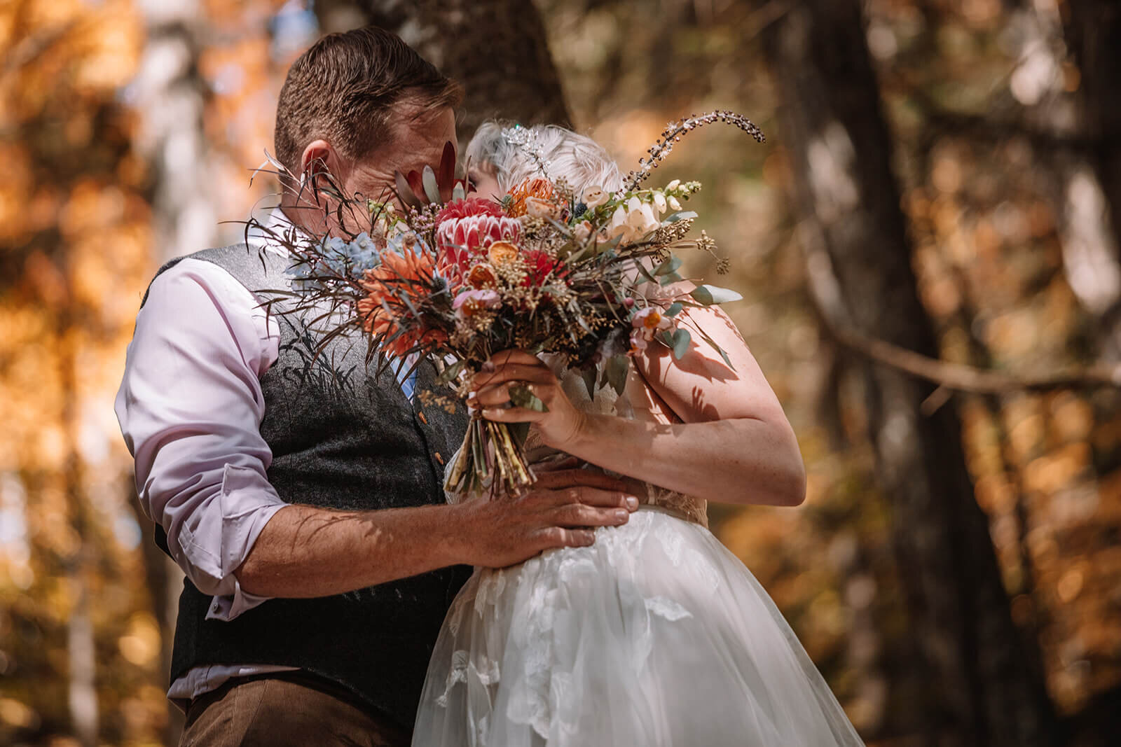  Bride covers her face while she kisses her groom at their Autumn elopement in Vermont 