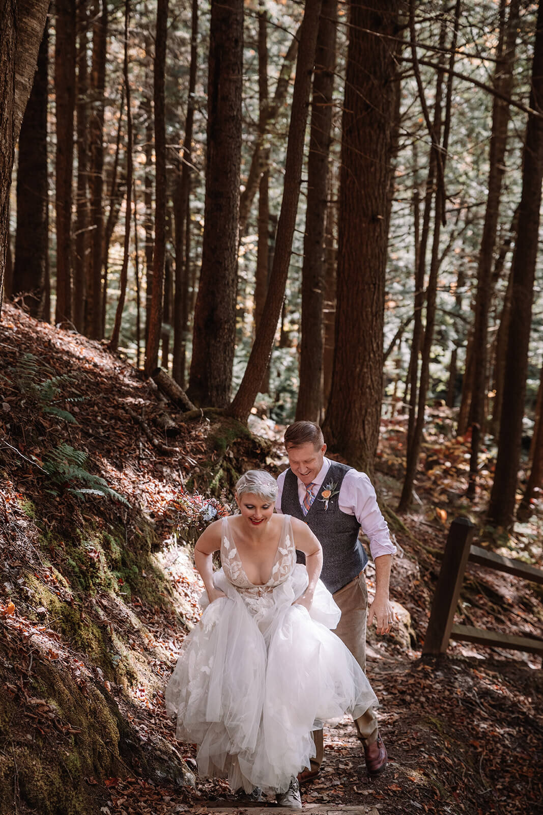  Bride and groom hike through the forest at Texas Falls Recreation area in Vermont after their elopement 