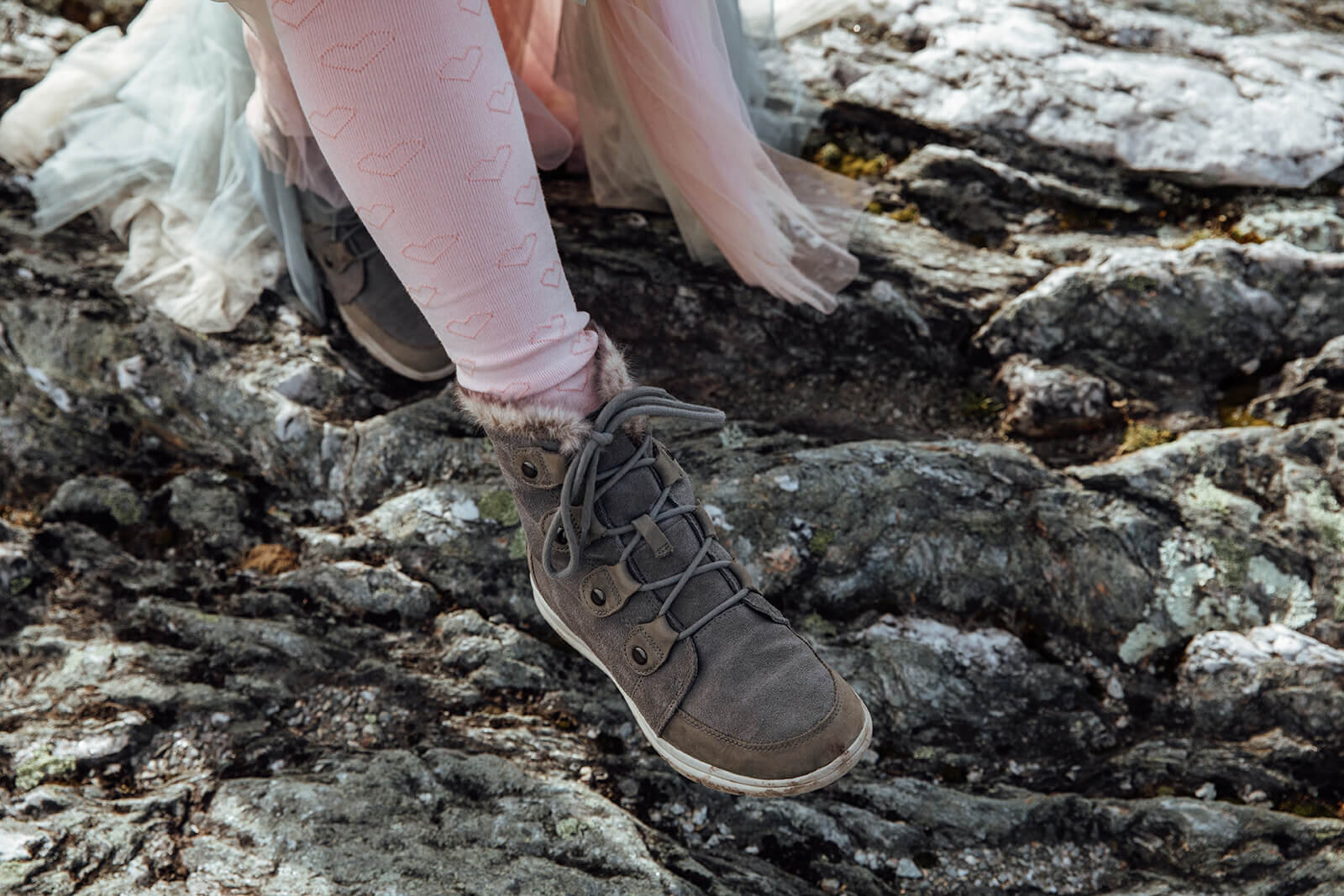  Bride shows off her hiking shoes and tights to keep warm under her dress during her fall elopement on top of Mt. Mansfield in Vermont 