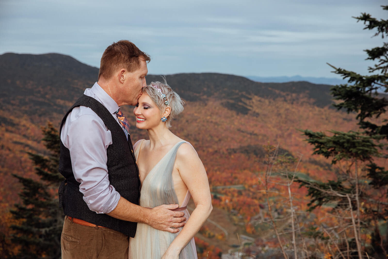  Groom kisses bride on the forehead during their Vermont elopement on Mt. Mansfield near Stowe 