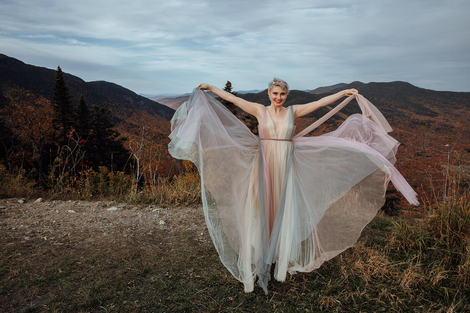  Bride plays with her rainbow dress on top of Mt. Mansfield near Stowe during her fall elopement 