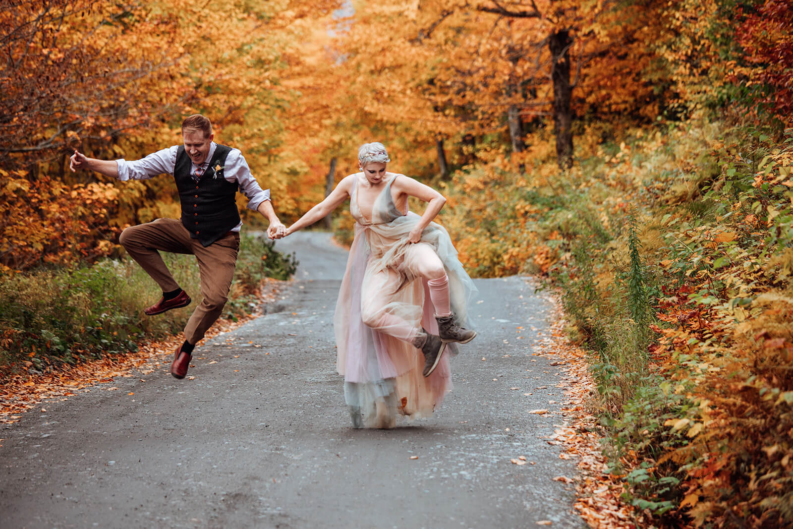  Couple jumps and runs through colorful tree tunnel after their elopement in Stowe, Vermont on Mt. Mansfield 
