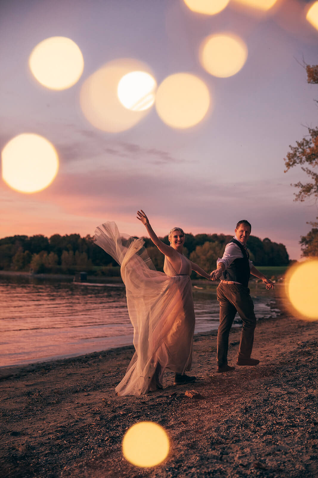  Bride and groom wave goodbye as the fireflies dance at Lake Champlain near Burlington, VT 