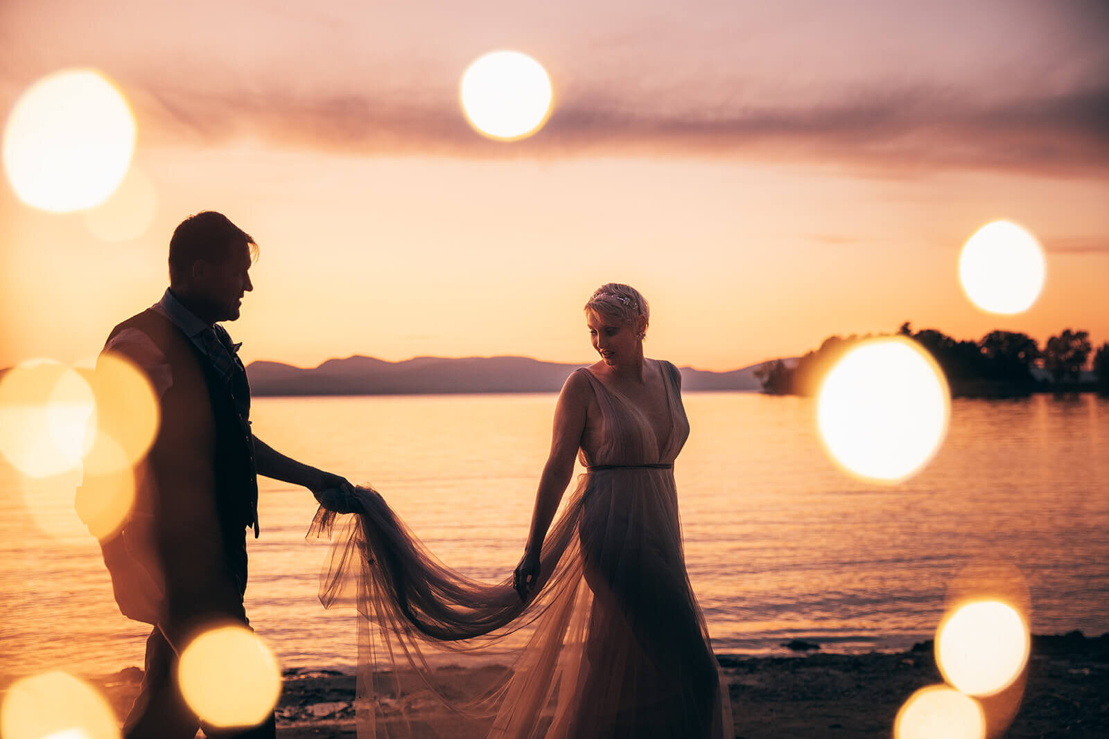  Bride and groom walk along  Lake Champlain near Burlington, VT after their fall elopement 