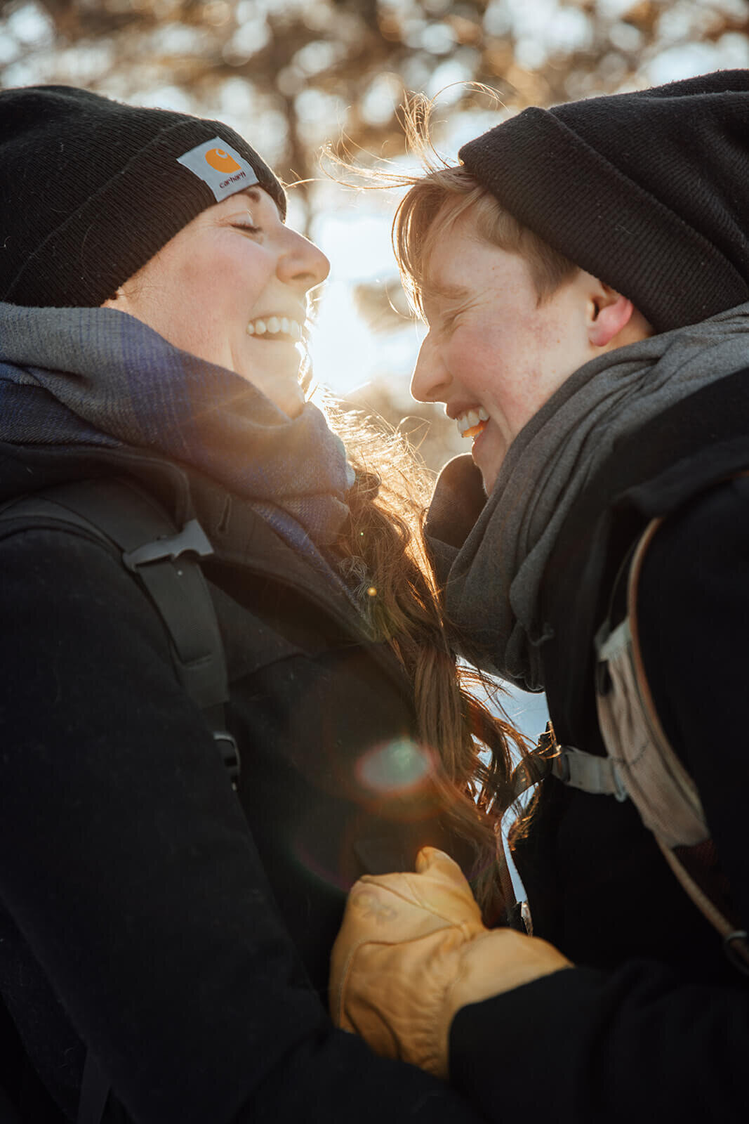  Couple laugh as sunsets on Mt. Major in New Hampshire in the winter for their anniversary. New Hampshire couples photographer 