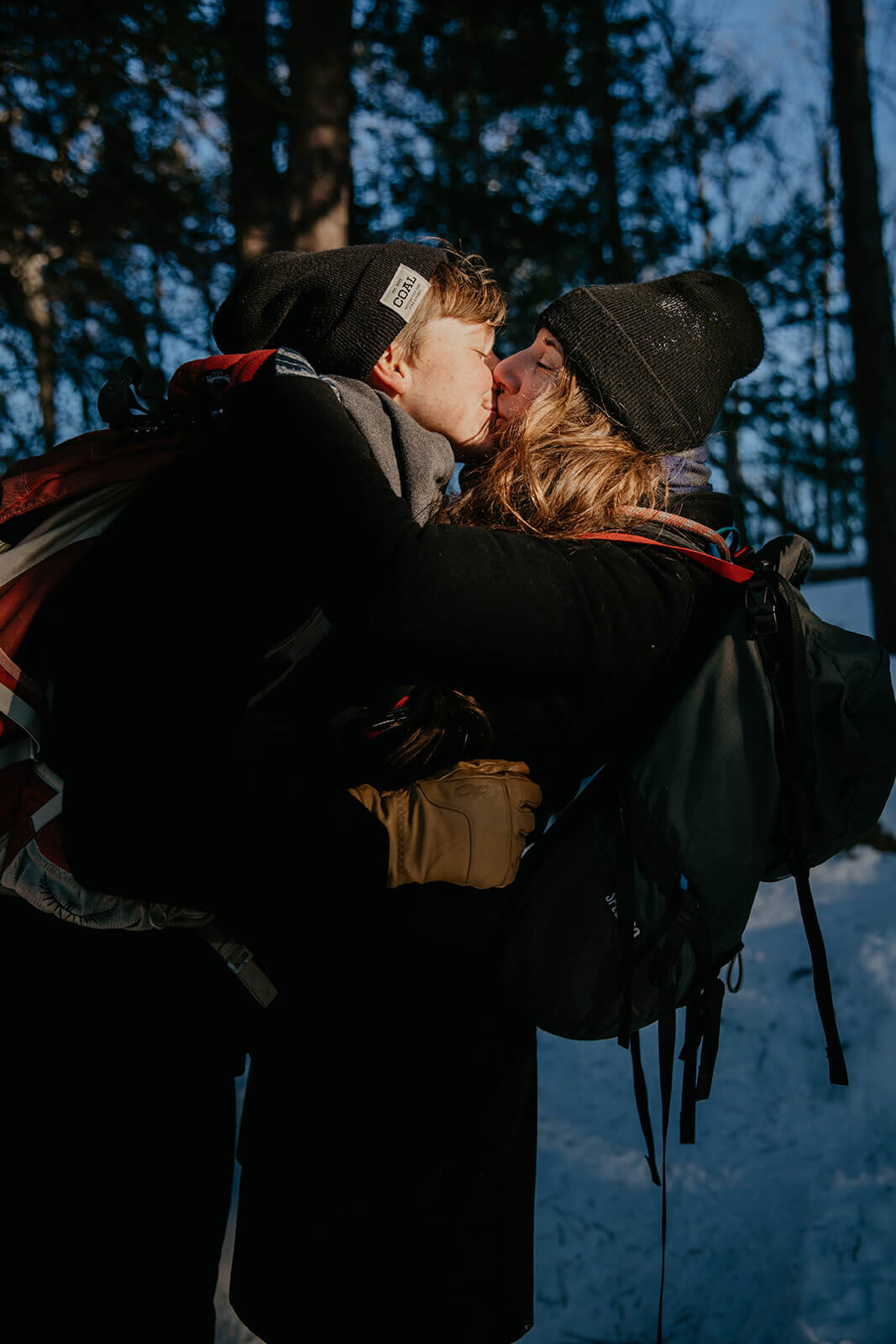  Couple laughs as sunsets on Mt. Major in New Hampshire in the winter for their anniversary. New Hampshire elopement photographer 