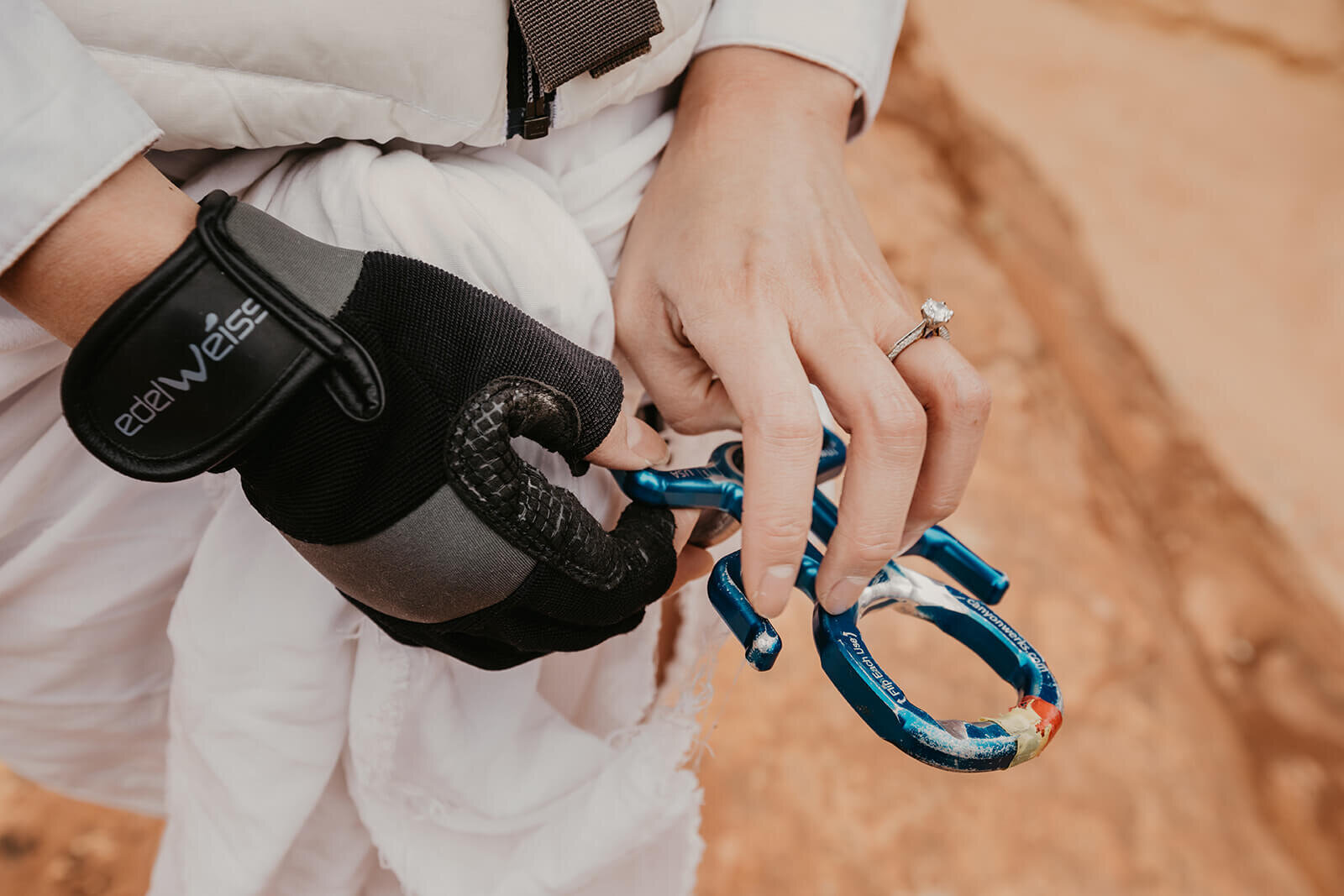  Bride shows off engagement ring with a rappel device known as an Imlay CRITR2 in a technical canyon outside of Zion National Park. Zion National Park elopement photographer 