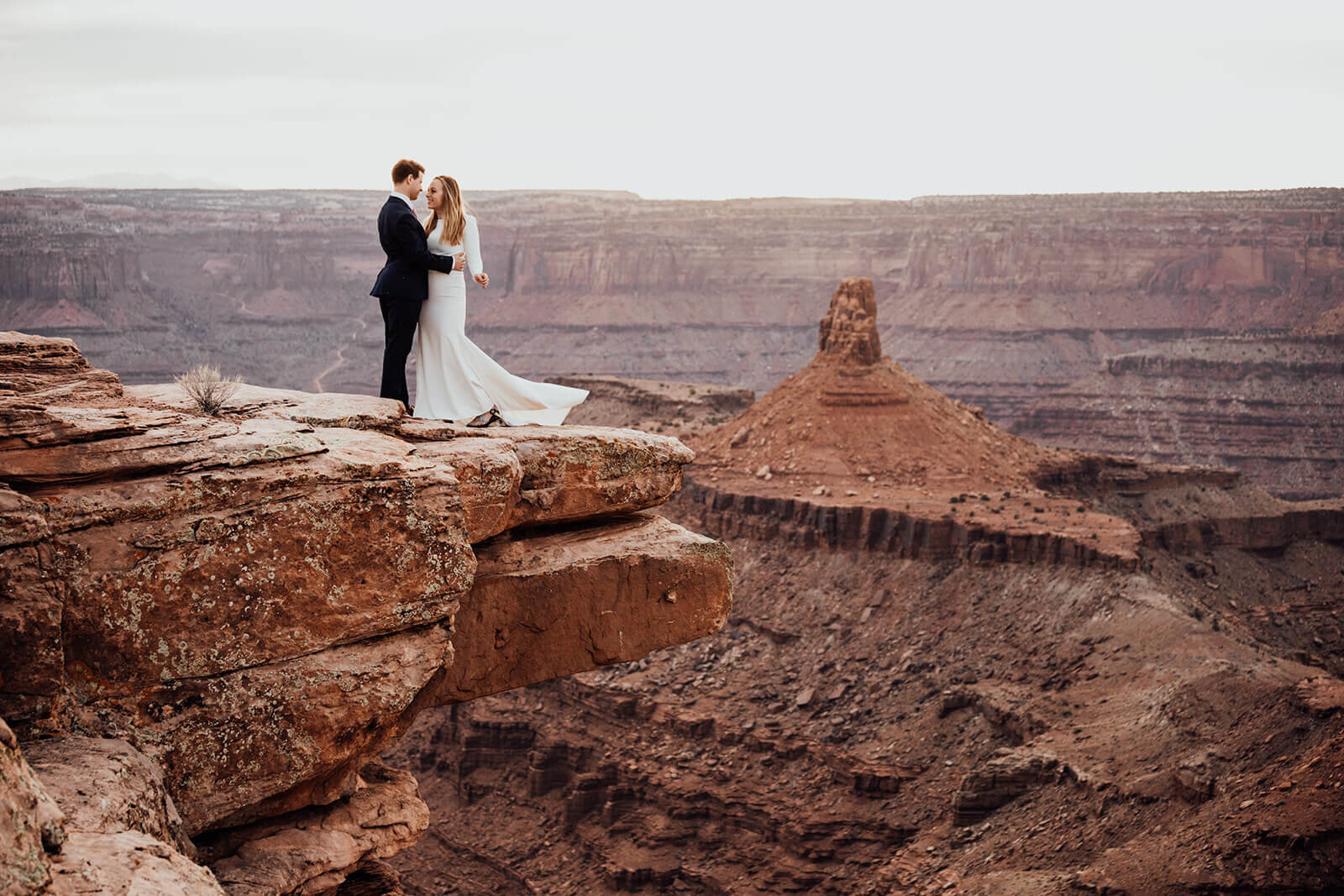  Couple celebrates anniversary at Dead Horse Point State Park and the La Sal Mountains near Moab, Utah with incredible views and hiking. Utah wedding photographer 