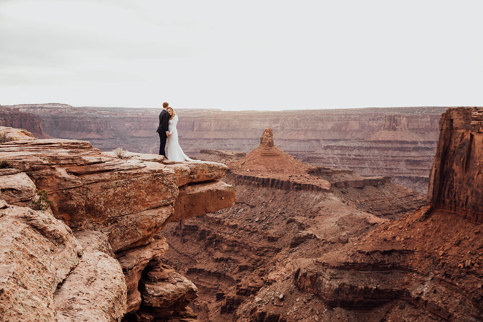  Couple celebrates anniversary at Dead Horse Point State Park and the La Sal Mountains near Moab, Utah with incredible views and hiking. Utah wedding photographer 