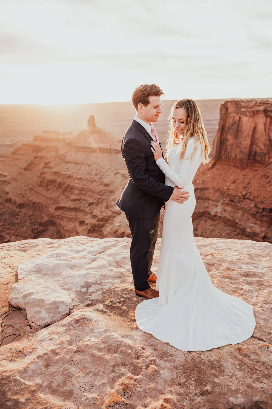  Couple celebrates anniversary at Dead Horse Point State Park and the La Sal Mountains near Moab, Utah with incredible views and hiking. Utah elopement photographer 