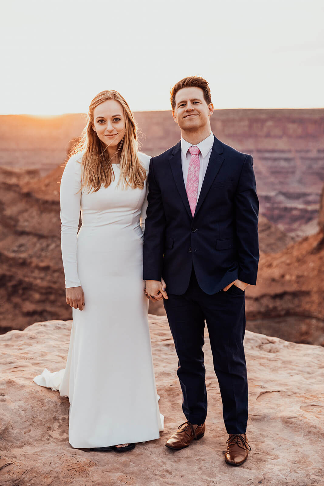  Couple celebrate anniversary during sunset at Dead Horse Point State Park and the La Sal Mountains near Moab, Utah with incredible views and hiking. Utah wedding photographer 
