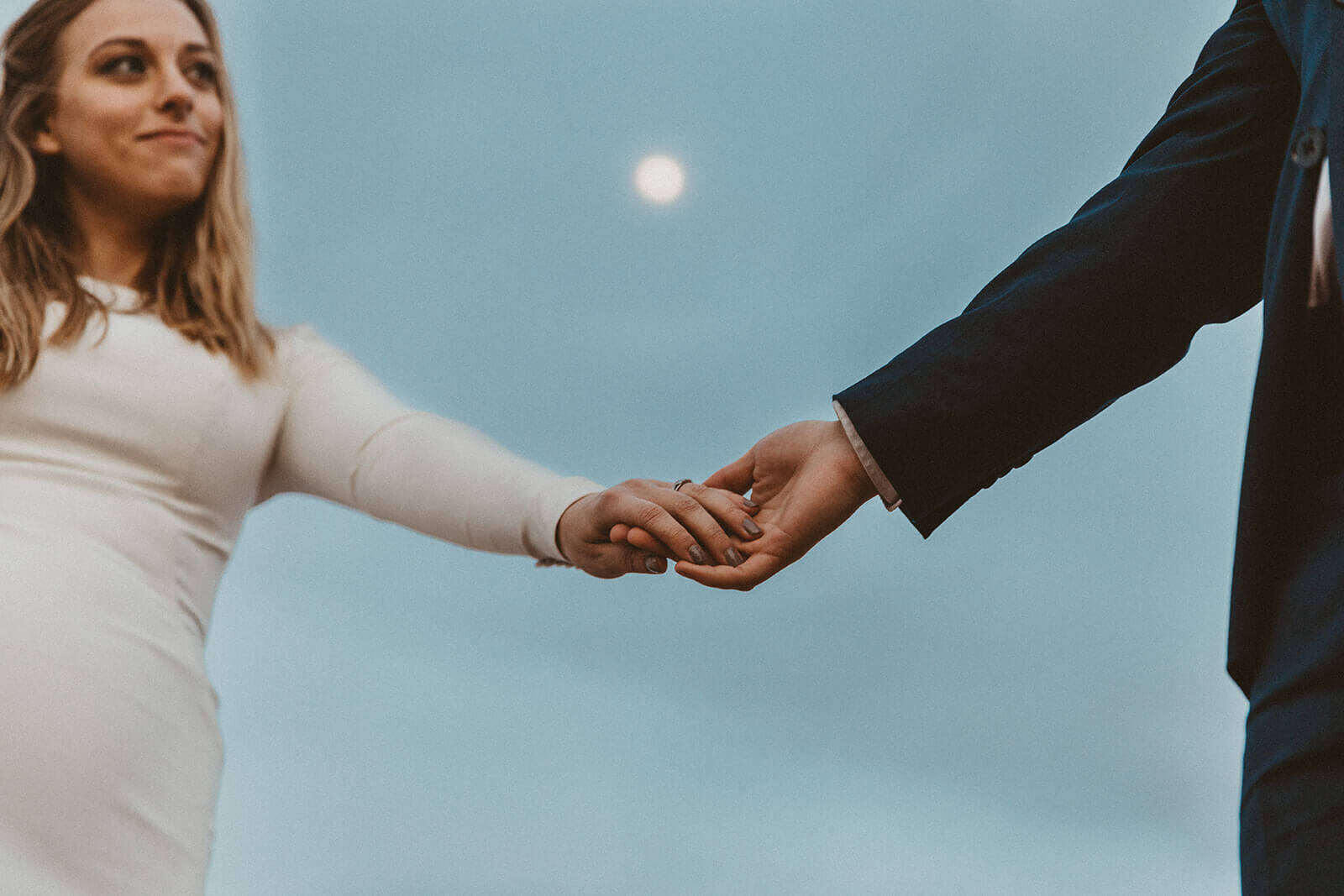  Couple hold hands as the moon rises outside of Moab, Utah. Moab elopement photographer 