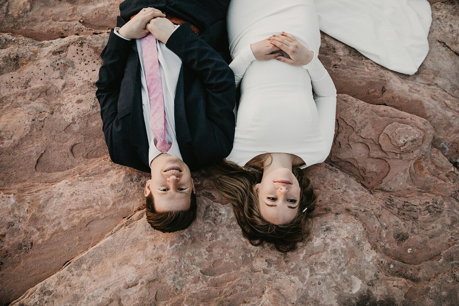  Couple lay on cliff edge during Moab elopement. Dead Horse Point elopement 