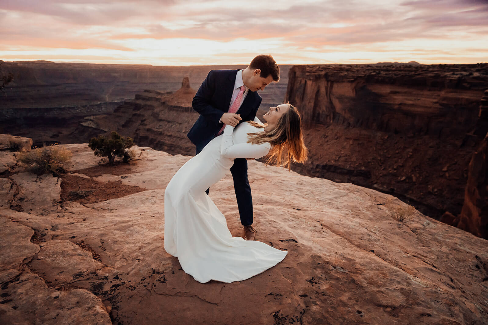  Couple share first dance during sunset at Dead Horse Point State Park. Moab wedding photographer 