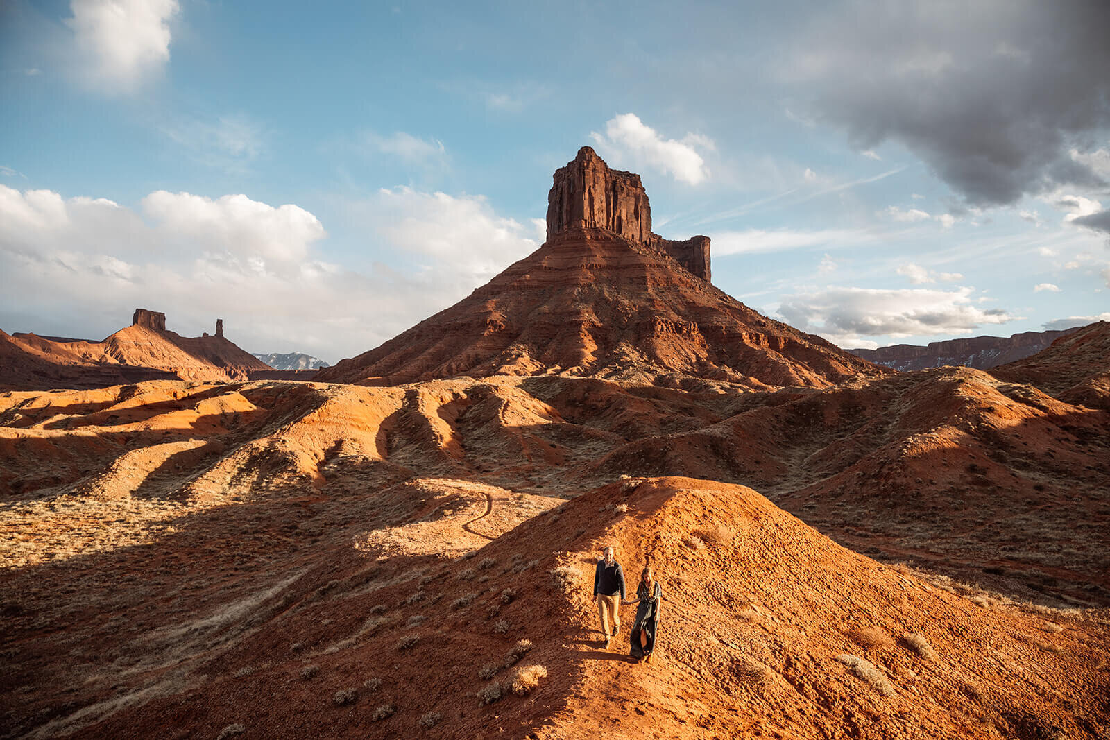  Couple hold hands in front of desert towers on public lands outside of Moab, Utah. Moab elopement photographer. 