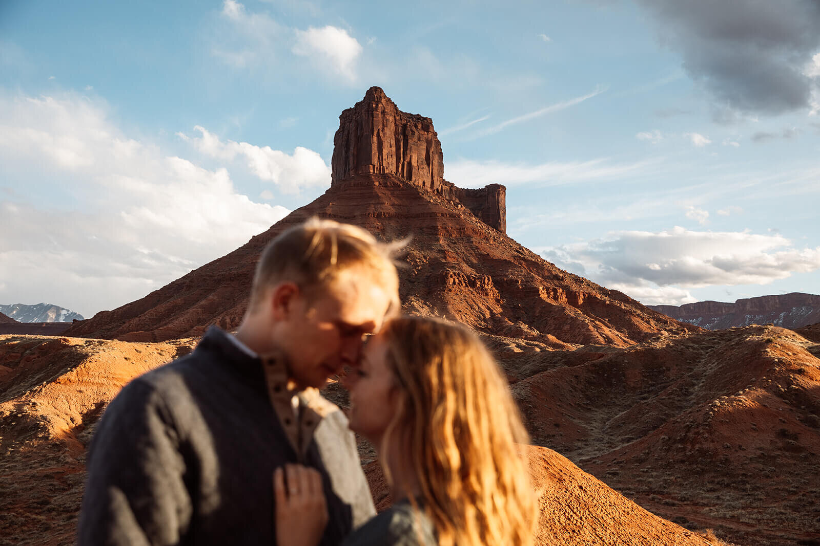  Couple kiss in front of desert towers on public lands outside of Moab, Utah. Moab elopement photographer. 