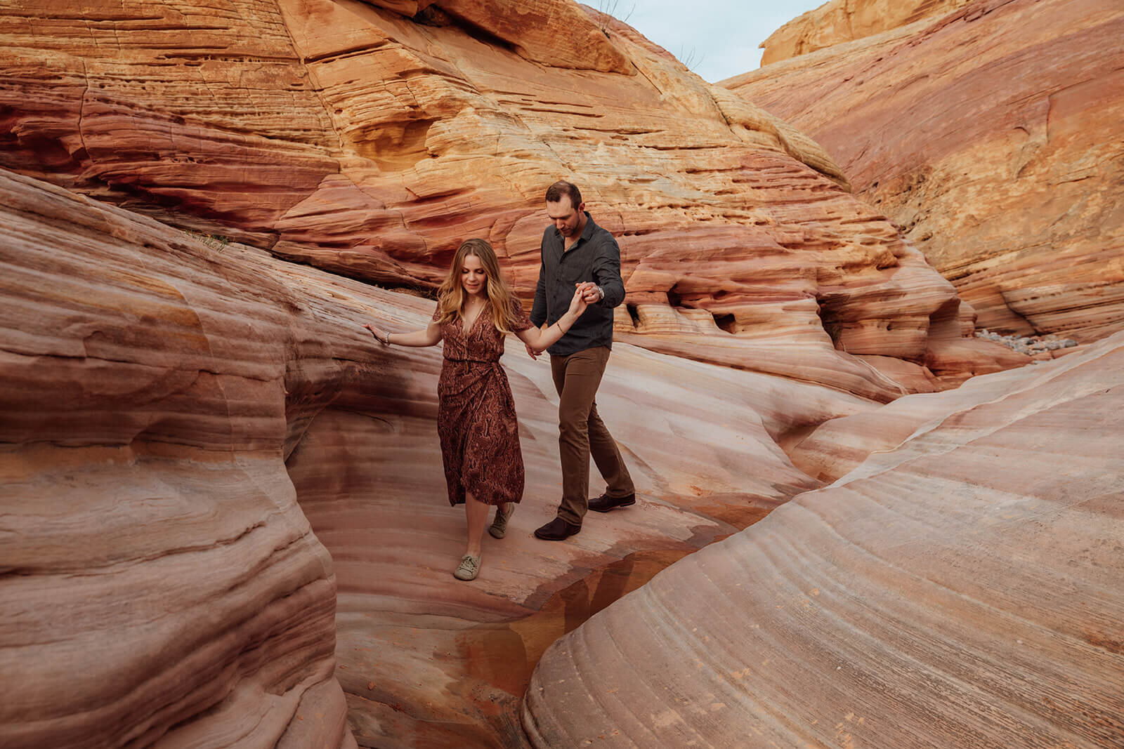  Couple explores a canyon in Valley of Fire State Park next to Lake Mead, outside of Las Vegas, Nevada. Desert southwest elopement photographer 