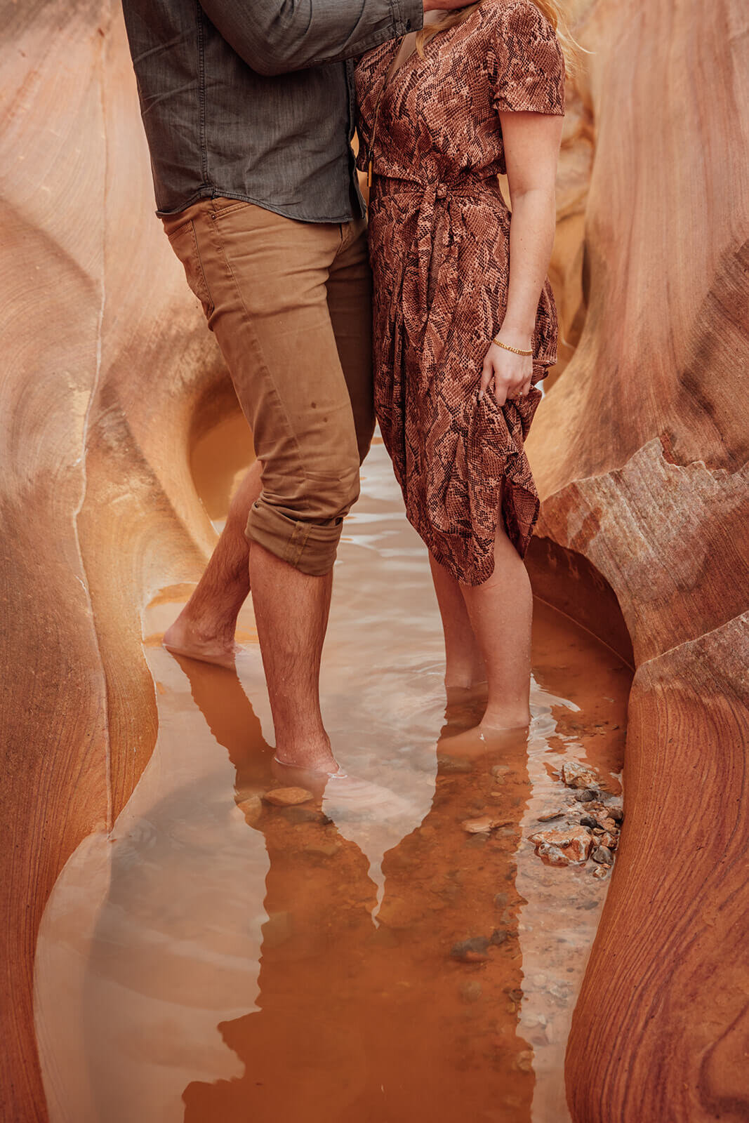  Couple wade through canyon in Valley of Fire State Park next to Lake Mead, outside of Las Vegas, Nevada. Nevada elopement photographer 