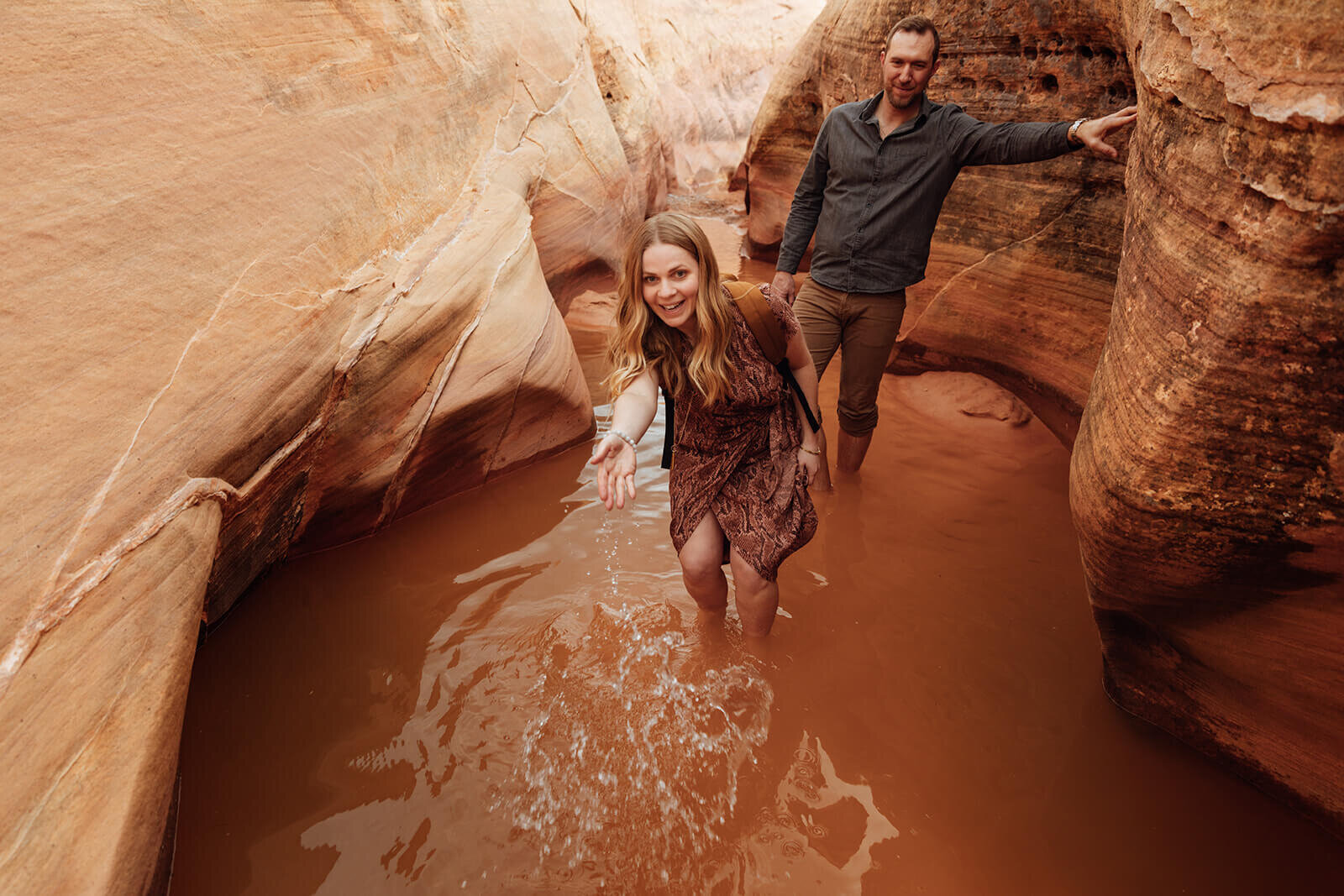  Couple wade through canyon in Valley of Fire State Park next to Lake Mead, outside of Las Vegas, Nevada. Nevada elopement photographer 