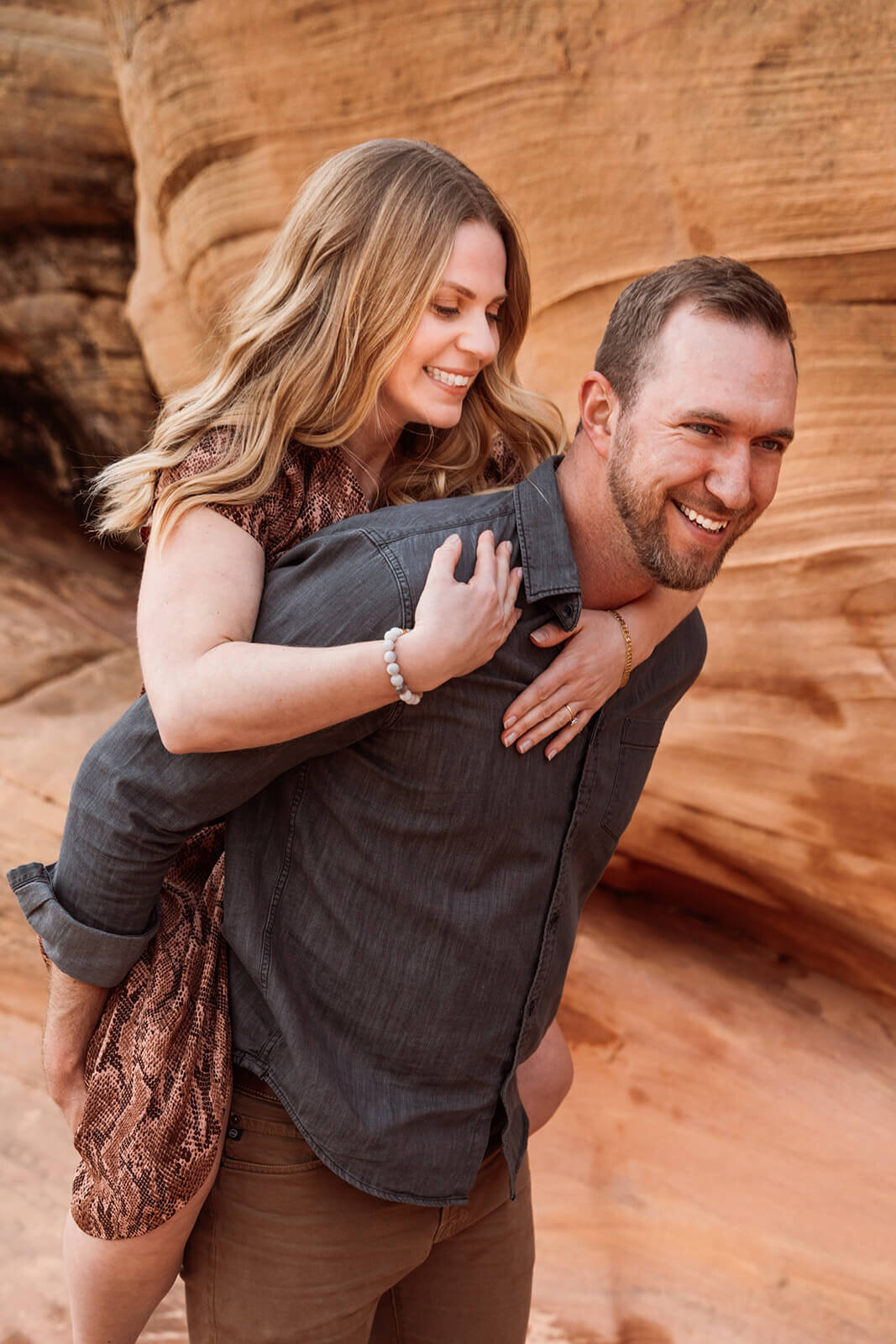  Couple walk through canyon in Valley of Fire State Park next to Lake Mead, outside of Las Vegas, Nevada. Nevada engagement photographer 