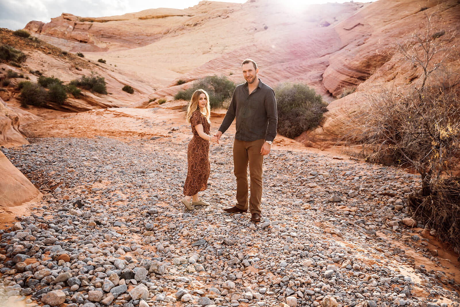  Couple walks through canyon in Valley of Fire State Park next to Lake Mead, outside of Las Vegas, Nevada. Nevada engagement photographer 