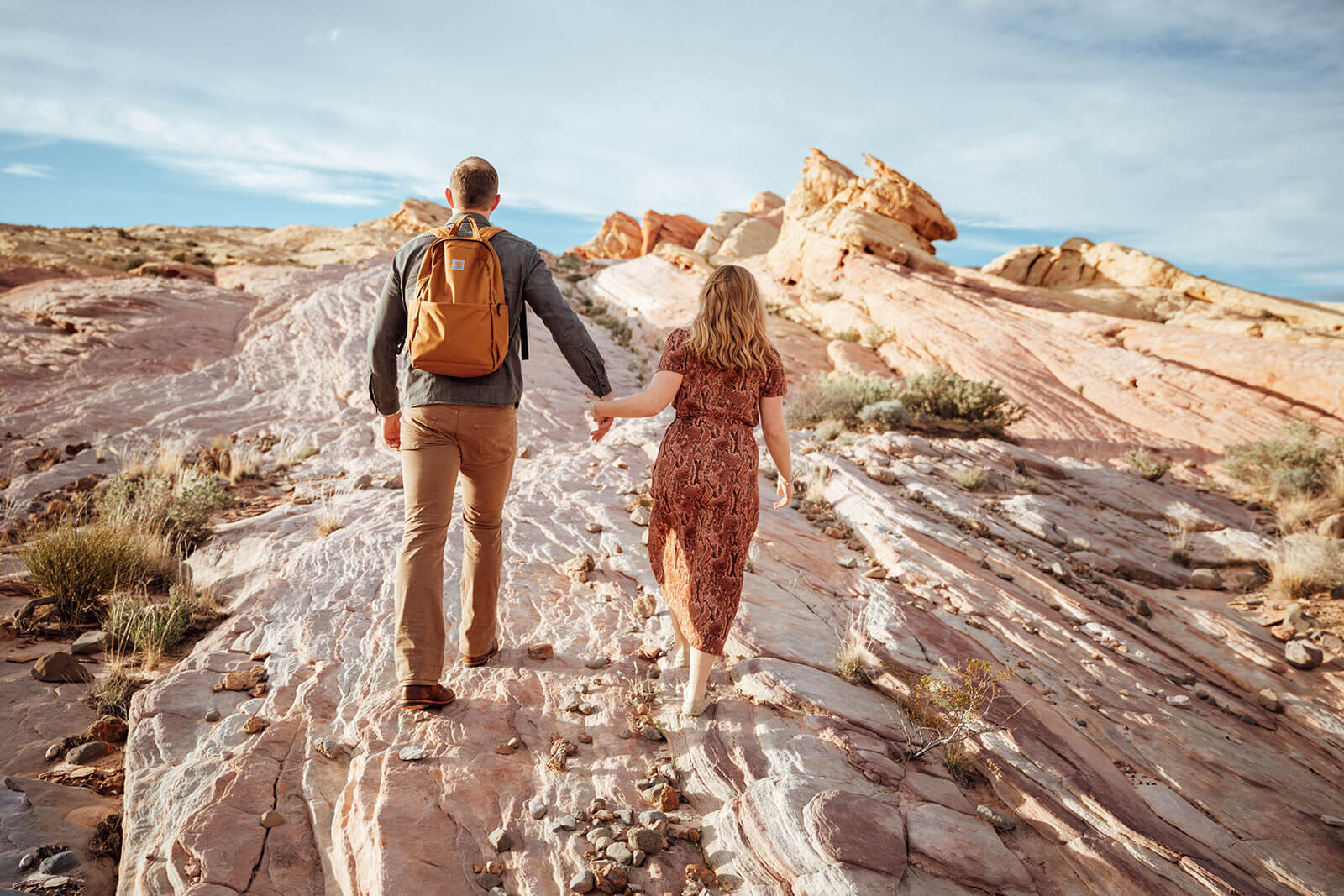  Couple hikes through canyon in Valley of Fire State Park next to Lake Mead, outside of Las Vegas, Nevada. Nevada engagement photographer 