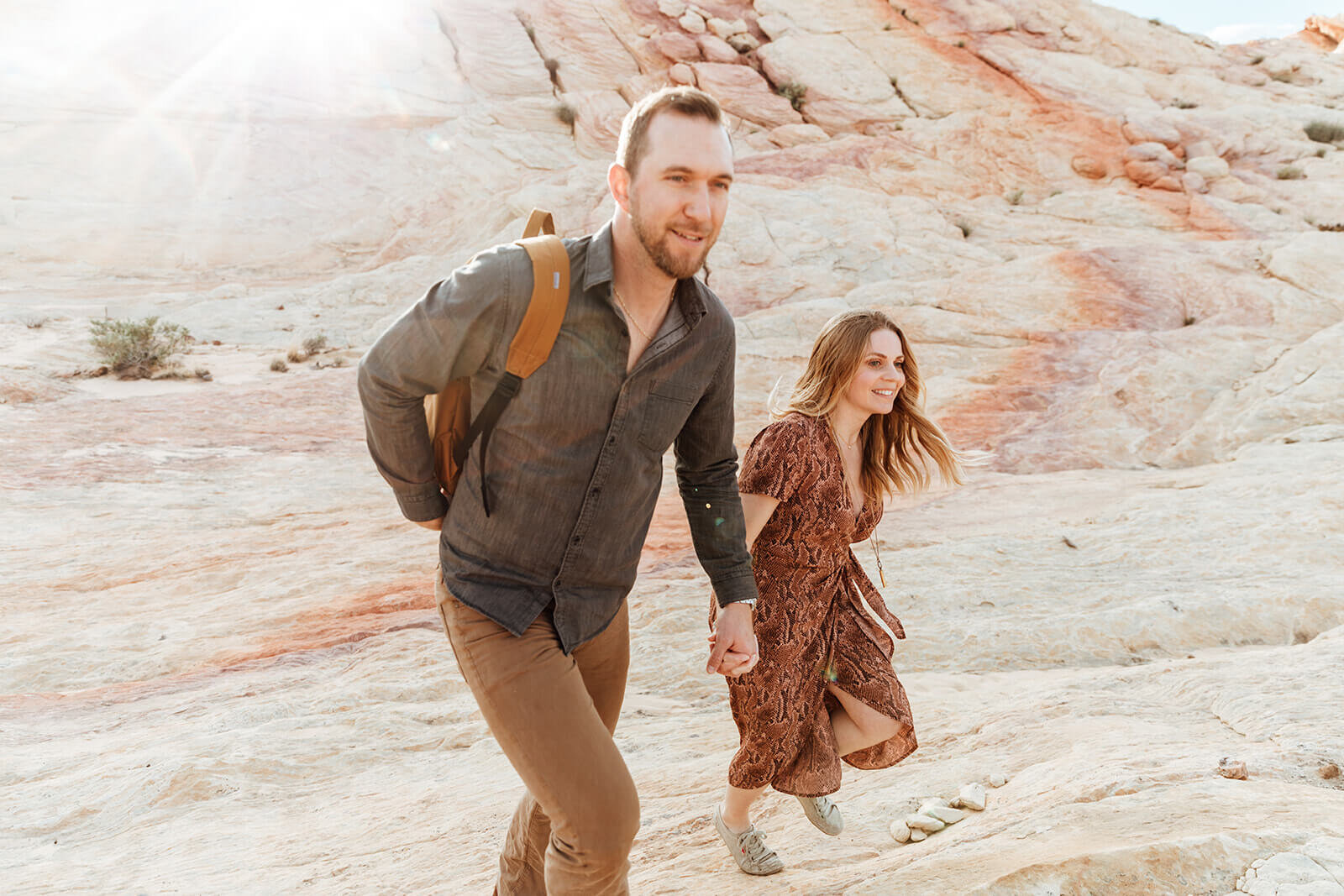  Couple hikes through canyon in Valley of Fire State Park next to Lake Mead, outside of Las Vegas, Nevada. Nevada engagement photographer 