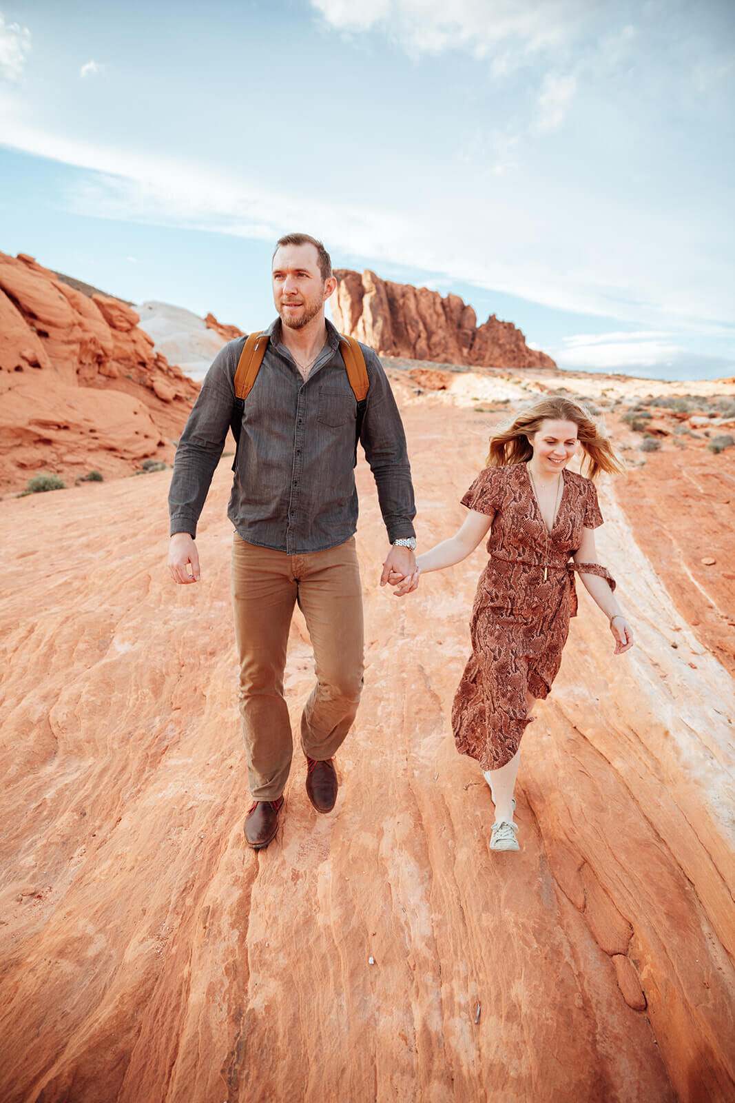  Couple hikes through canyon in Valley of Fire State Park next to Lake Mead, outside of Las Vegas, Nevada. Las Vegas engagement photographer 