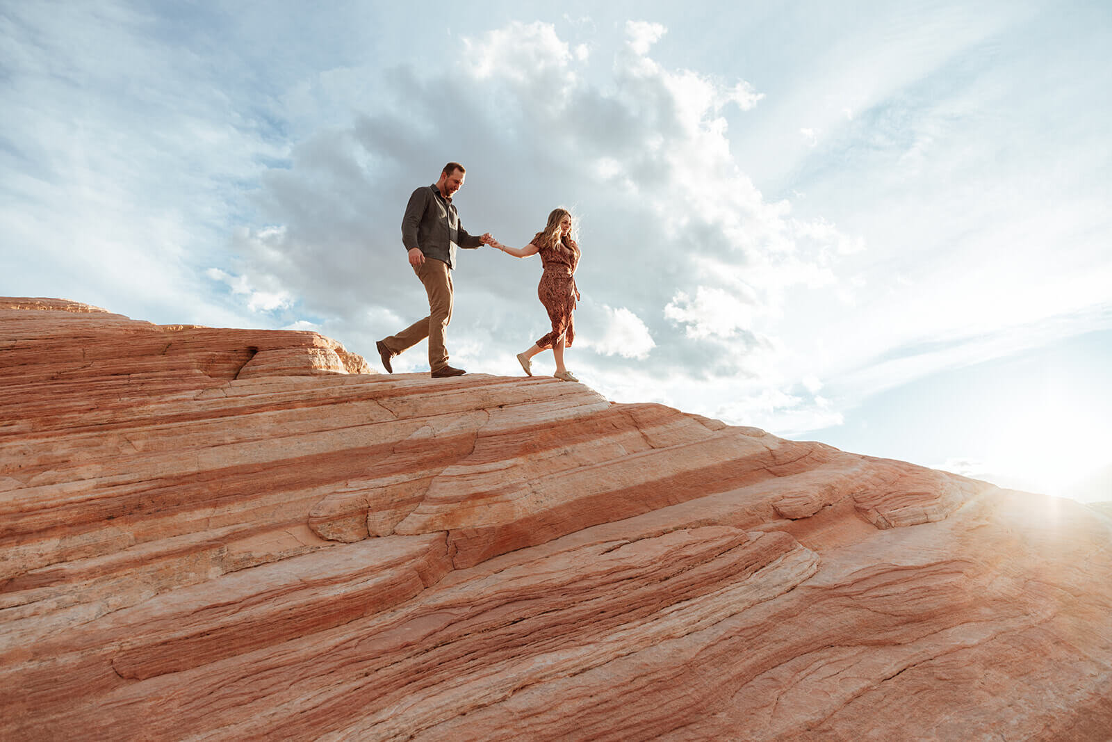  Couple hikes to the Fire Wave in Valley of Fire State Park next to Lake Mead, outside of Las Vegas, Nevada. Las Vegas engagement photographer 