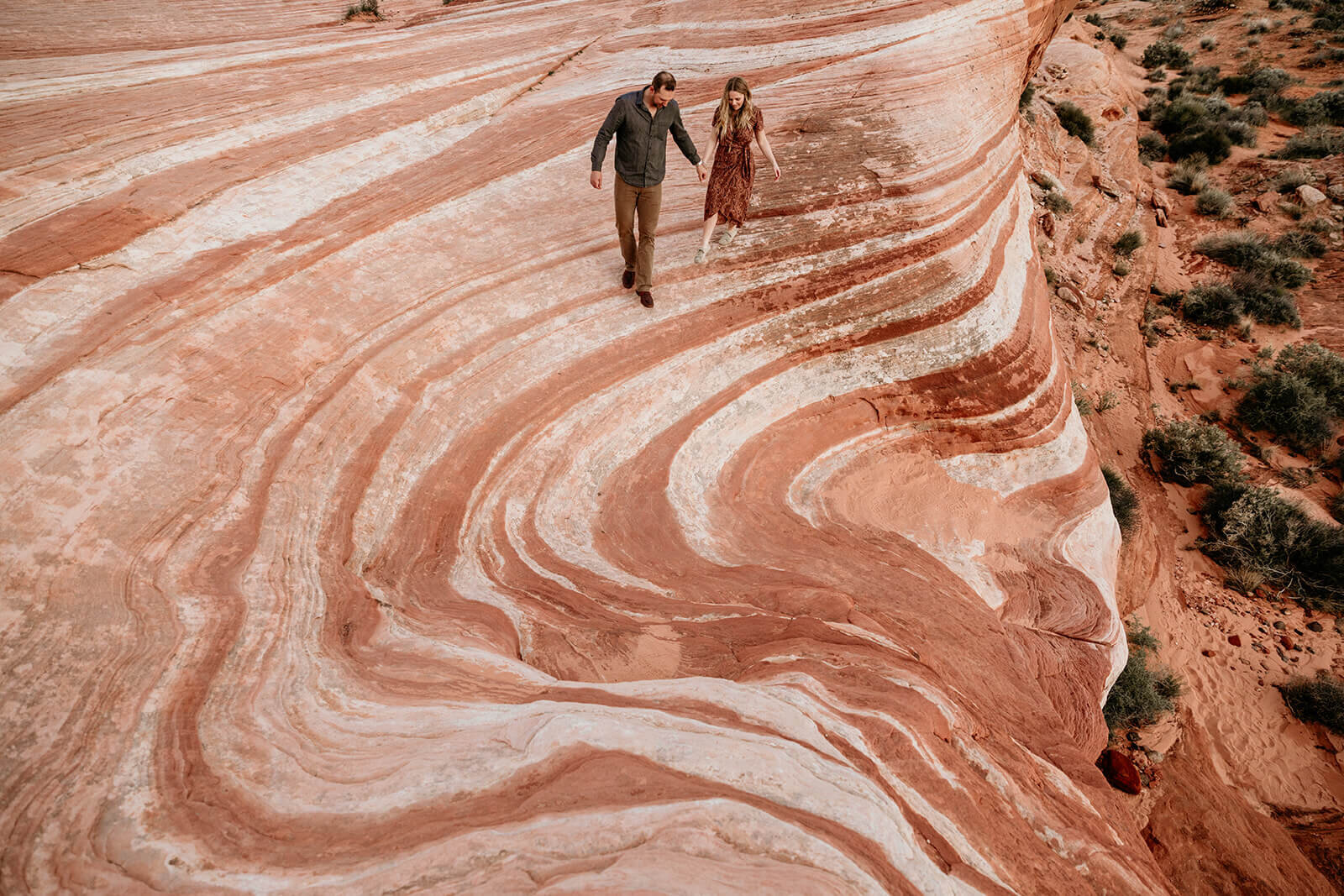  Couple hikes to the Fire Wave in Valley of Fire State Park next to Lake Mead, outside of Las Vegas, Nevada. Las Vegas elopement photographer 