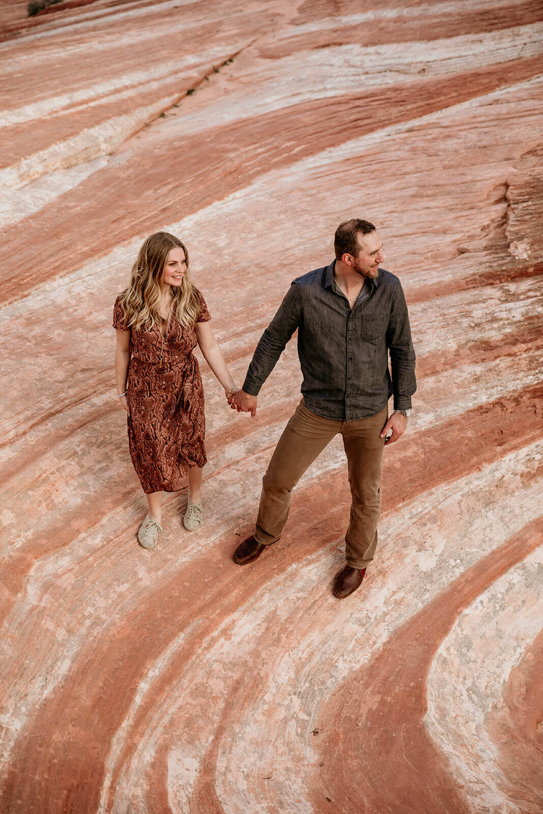  Couple hikes to the Fire Wave in Valley of Fire State Park next to Lake Mead, outside of Las Vegas, Nevada. Las Vegas elopement photographer 