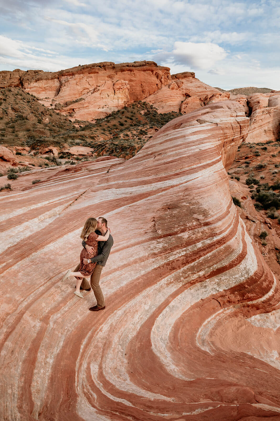  Couple hikes to the Fire Wave in Valley of Fire State Park next to Lake Mead, outside of Las Vegas, Nevada. Las Vegas elopement photographer 