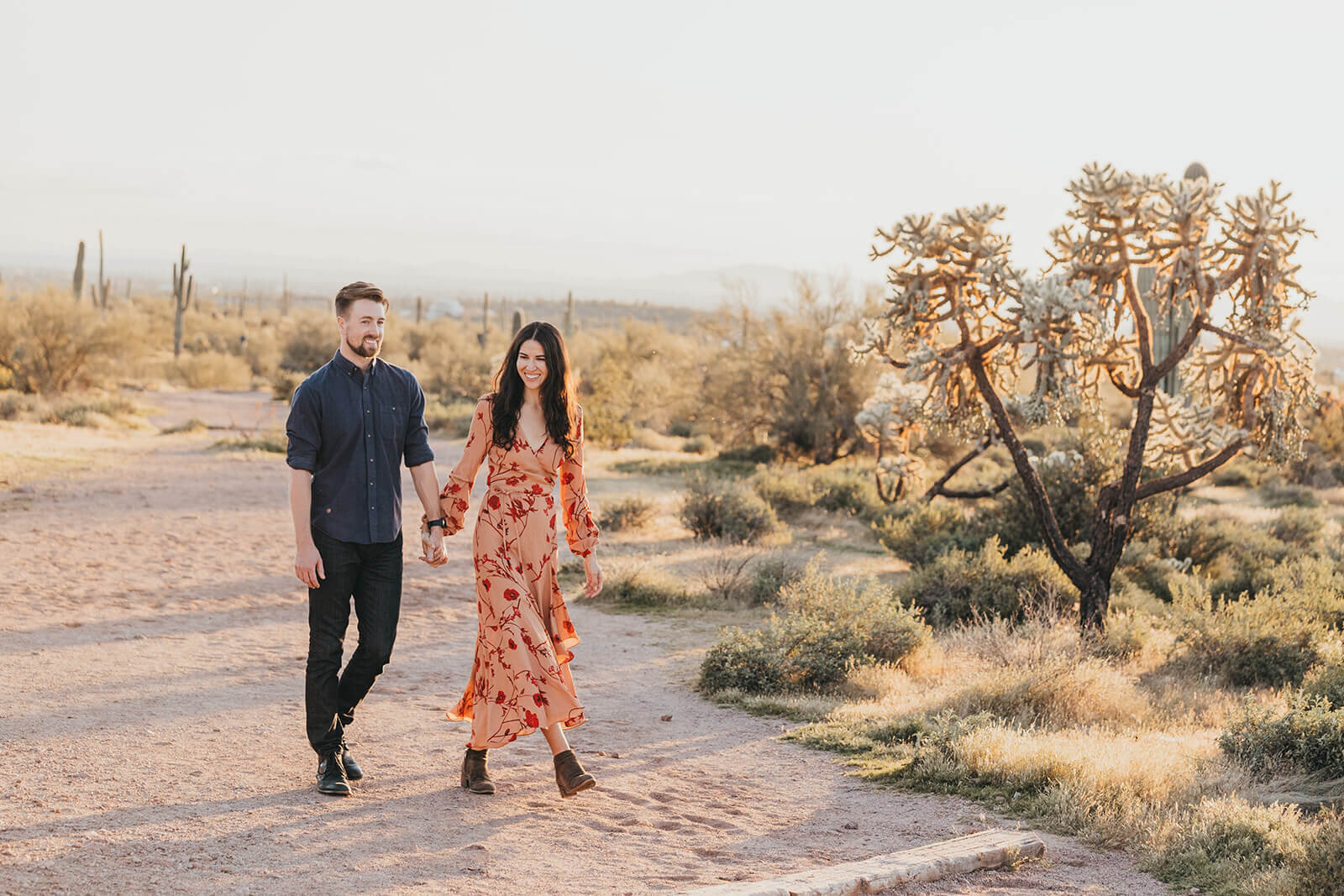  Couple hikes through desert wonderland during their engagement session in the Superstition Mountains outside of Phoenix, Arizona. Phoenix elopement photographer 