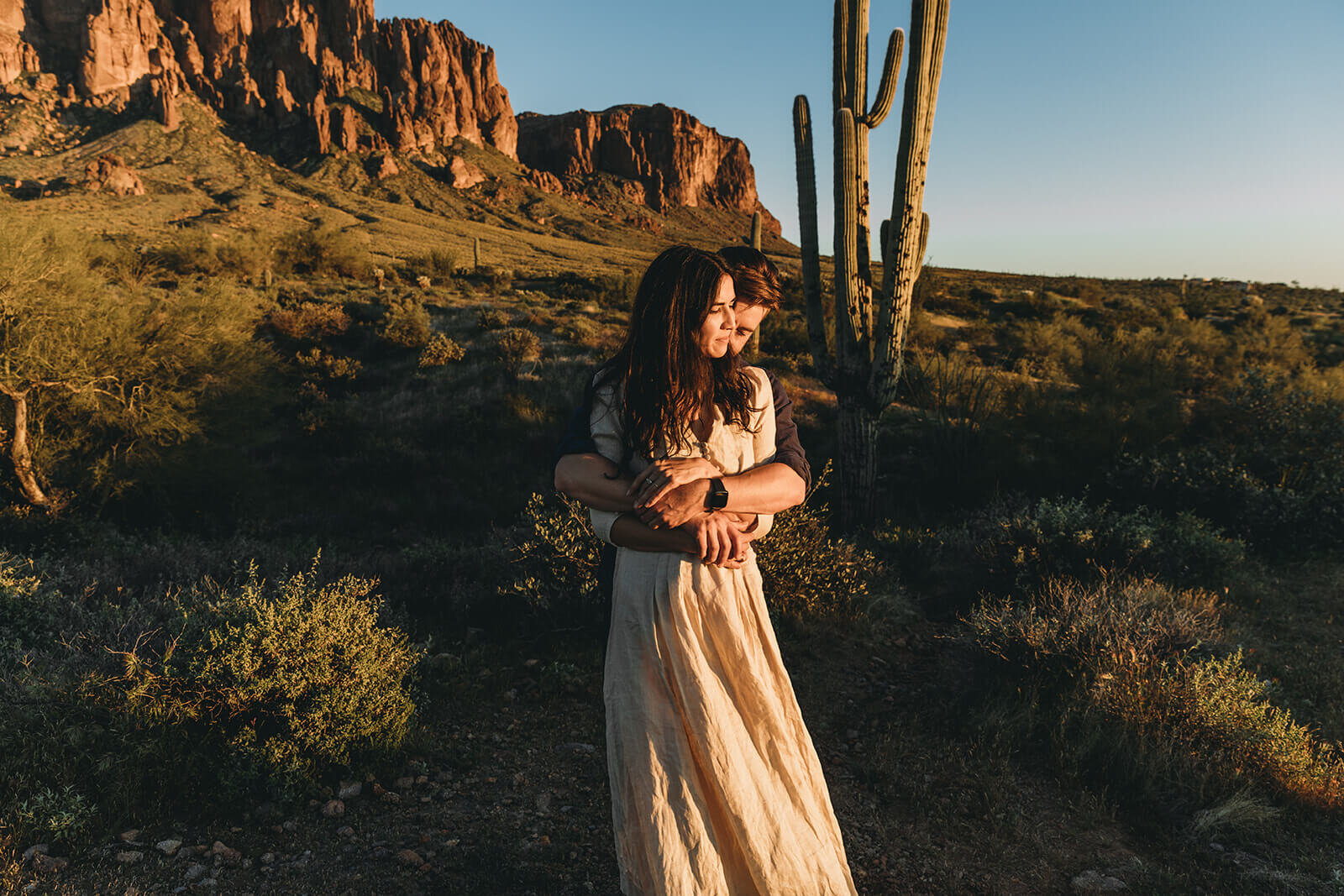  Couple hikes through desert wonderland during their engagement session in the Superstition Mountains outside of Phoenix, Arizona. Phoenix elopement photographer 