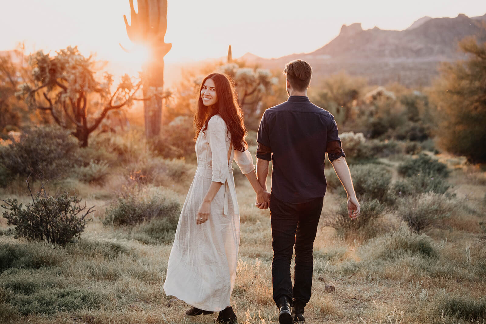  Couple hikes through desert wonderland during their engagement session in the Superstition Mountains outside of Phoenix, Arizona. Phoenix elopement photographer 