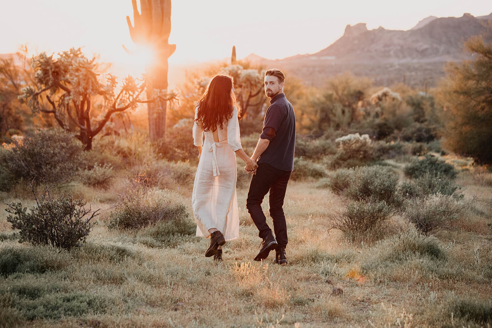  Couple hikes through desert wonderland during their engagement session in the Superstition Mountains outside of Phoenix, Arizona. Phoenix, Arizona elopement photographer 