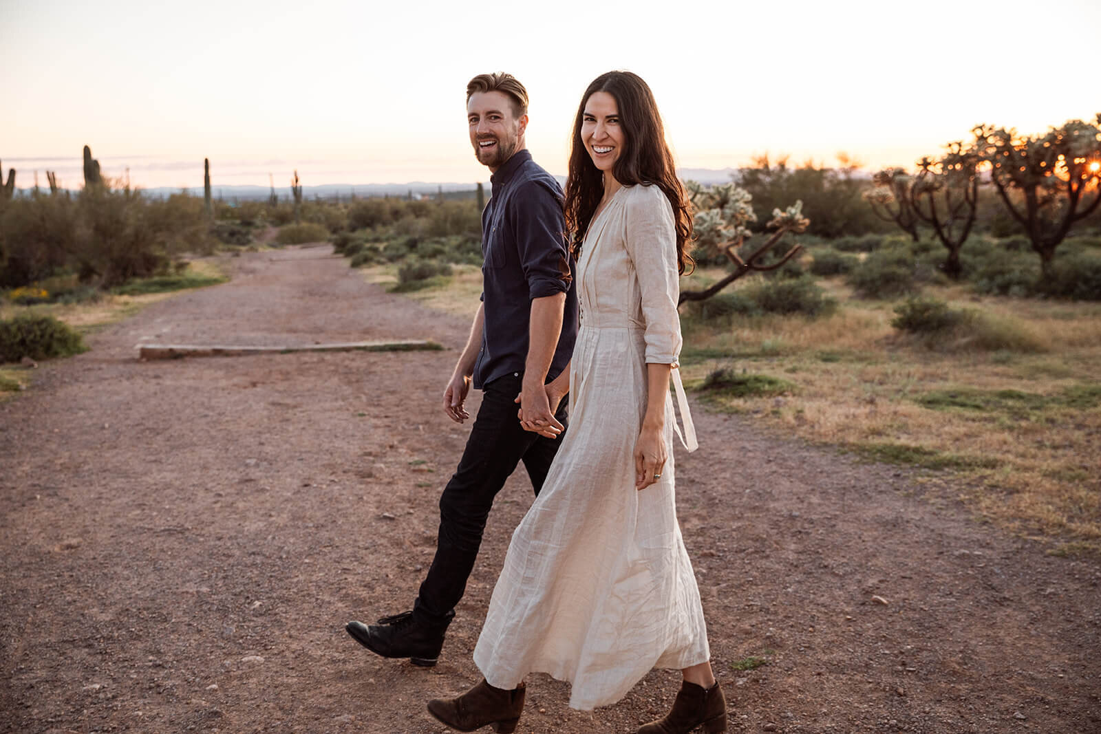  Couple hikes through desert wonderland during their engagement session in the Superstition Mountains outside of Phoenix, Arizona. Phoenix elopement photographer 