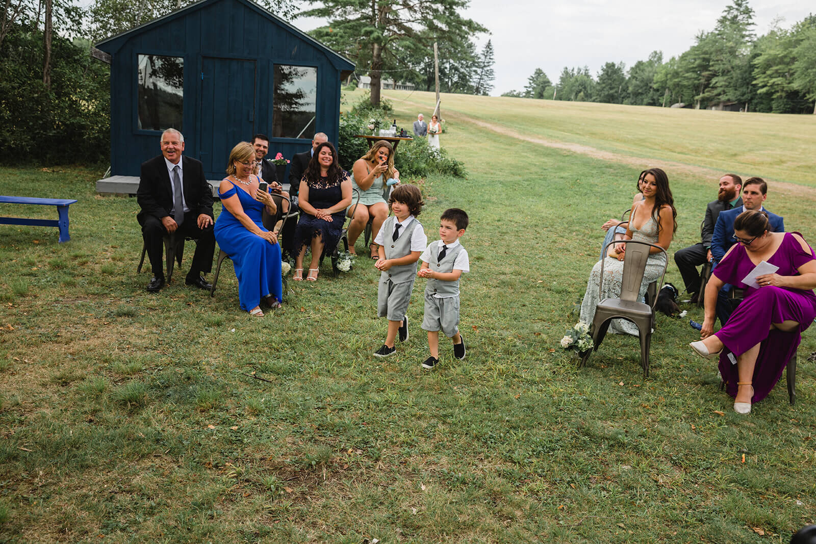  Ring bearers walk down aisle. Small outdoor wedding in Maine. 