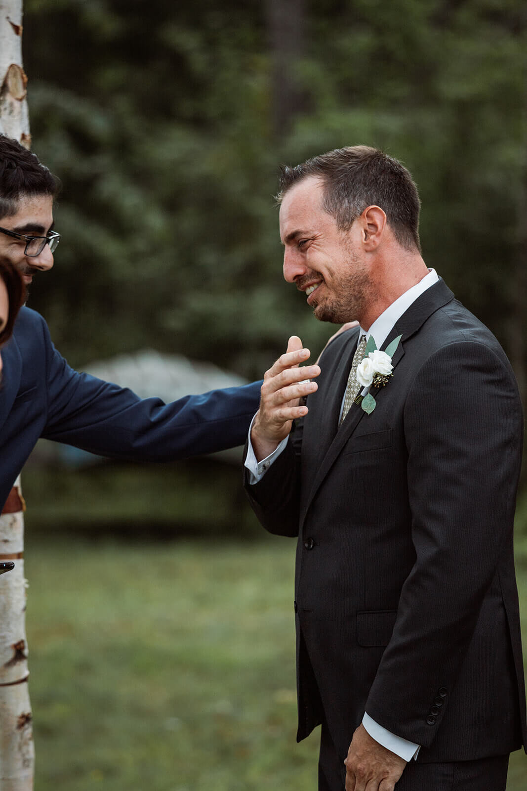  Groom reacts to seeing bride walk down the aisle. Small outdoor wedding in Maine. 