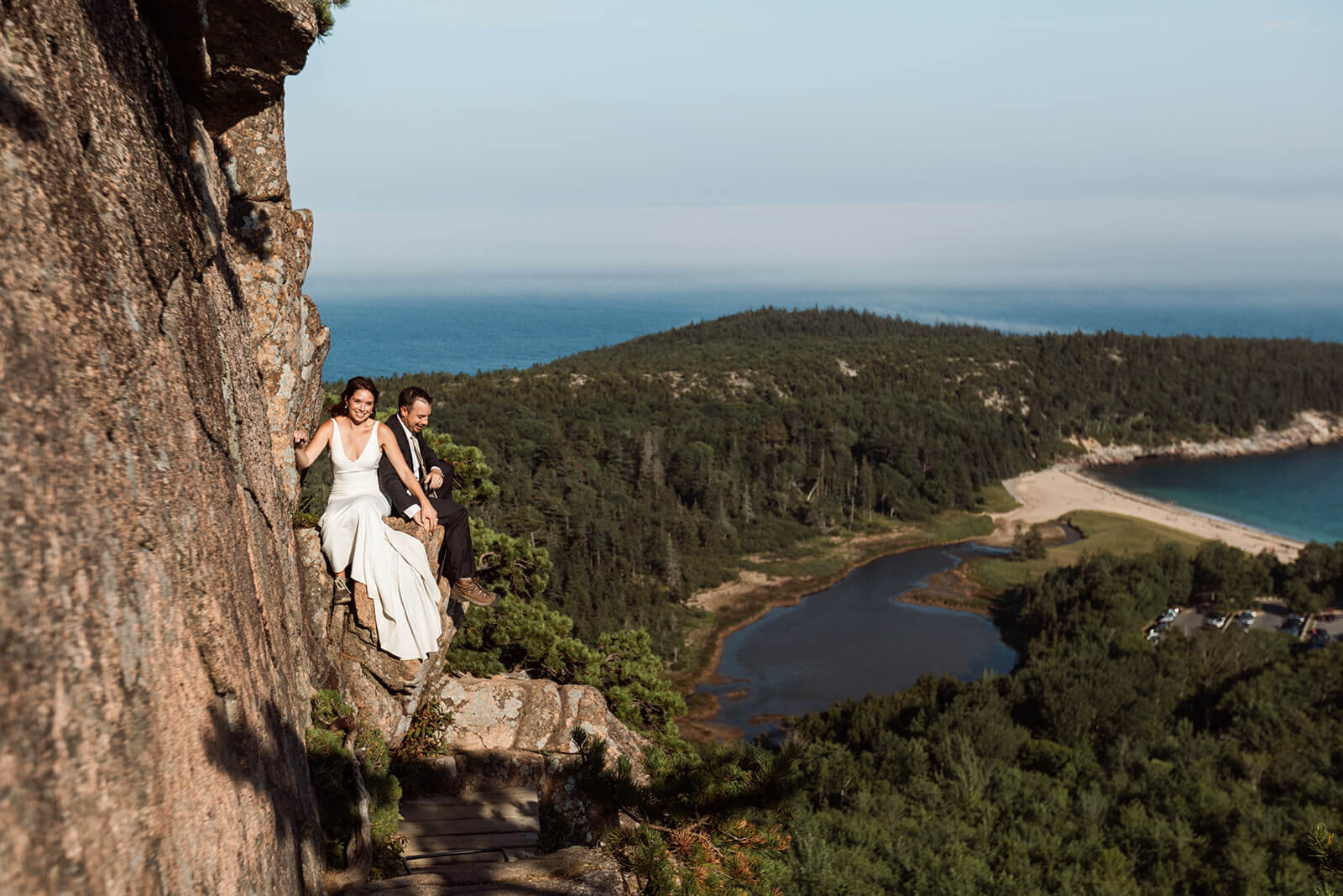  Couple takes in the views during their Acadia National Park elopement in Maine while hiking the Beehive. 