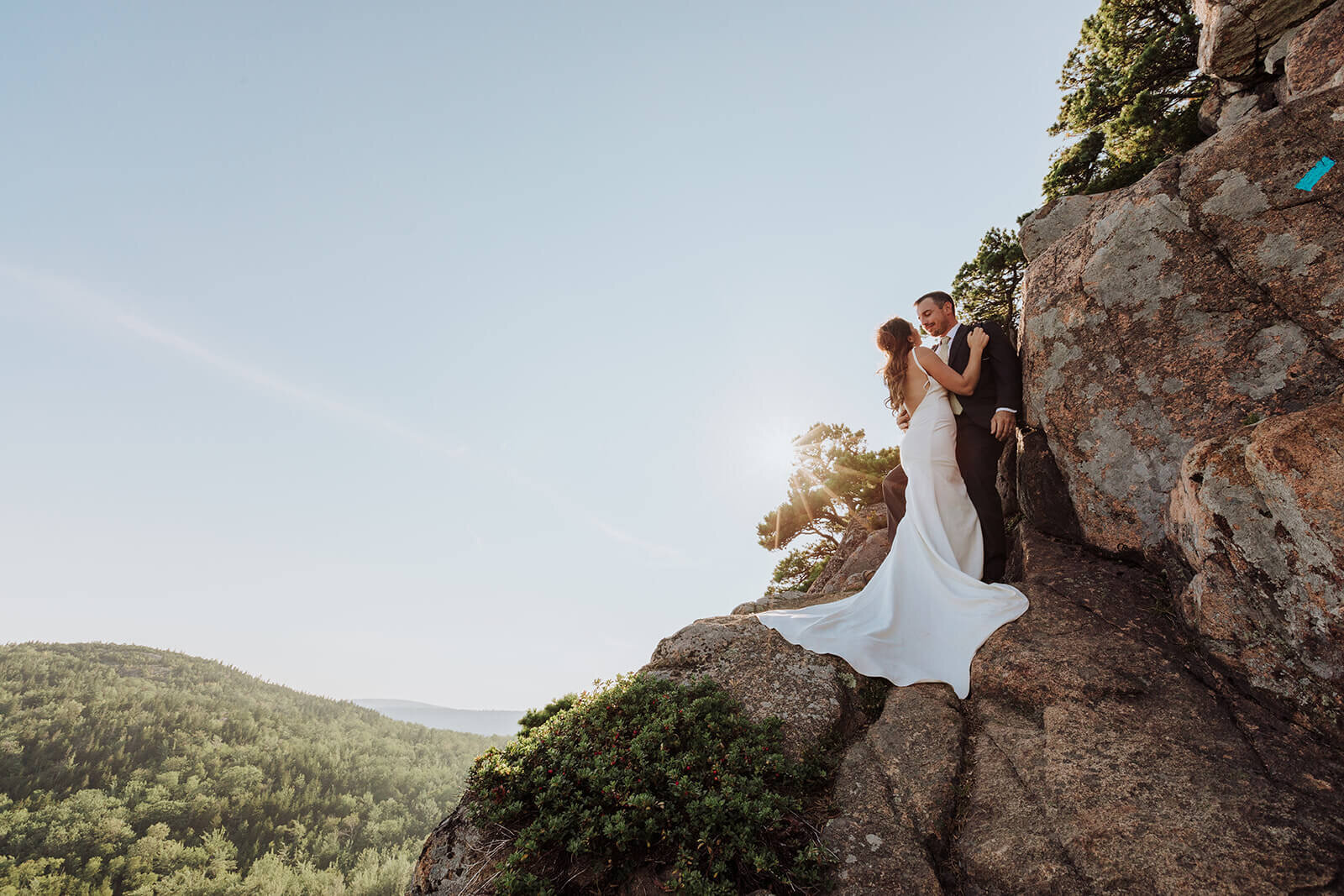  Couple takes in the views during their Acadia National Park elopement in Maine while hiking the Beehive. 