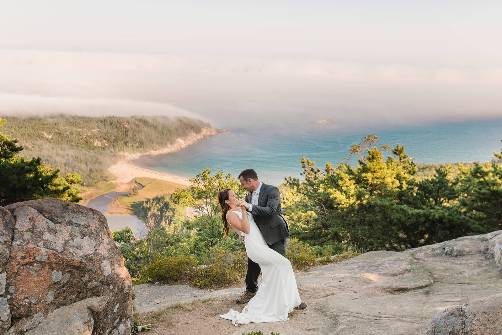  Couple takes in the views during their Acadia National Park elopement in Maine while hiking the Beehive. 